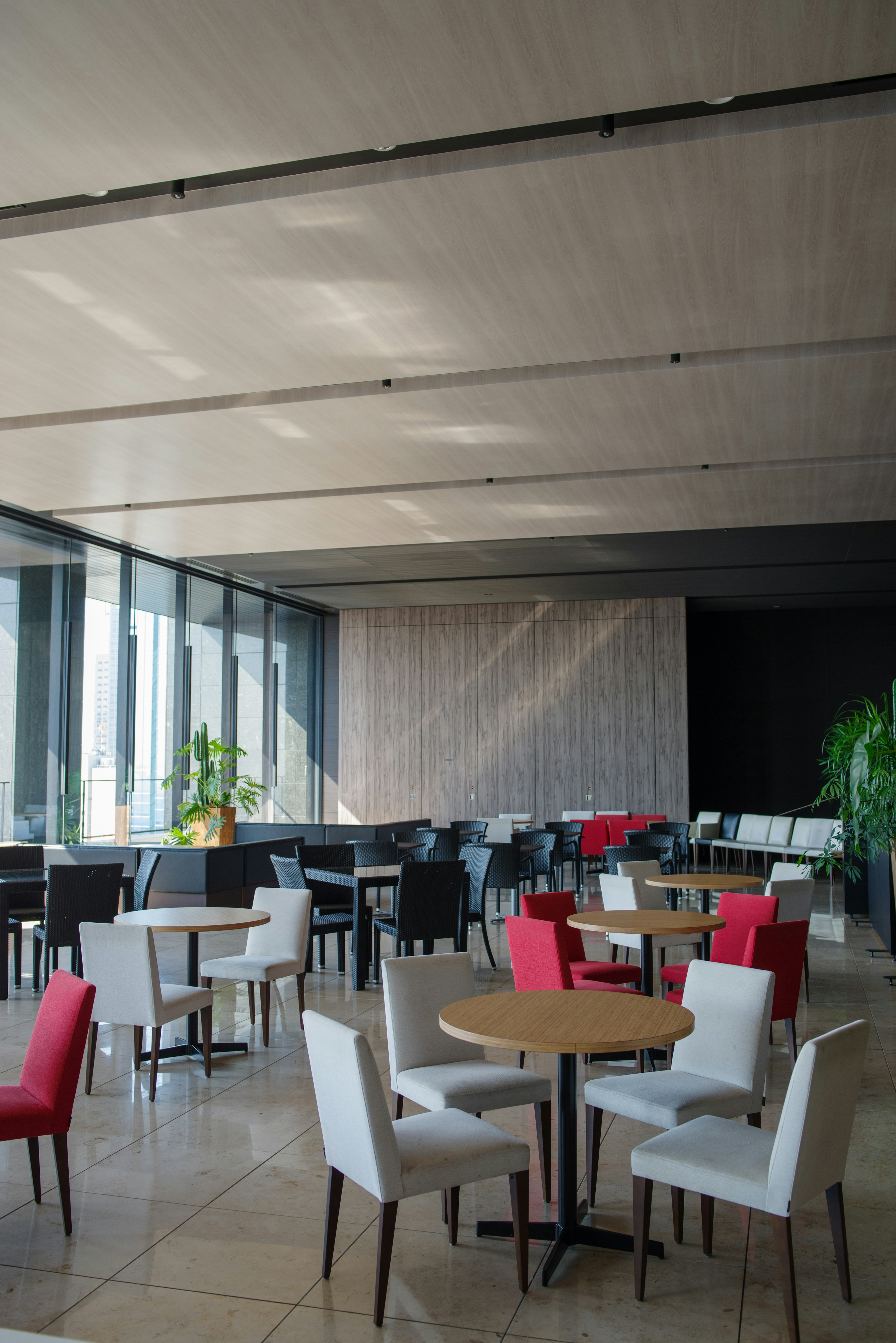 Modern restaurant interior with tables and red and white chairs