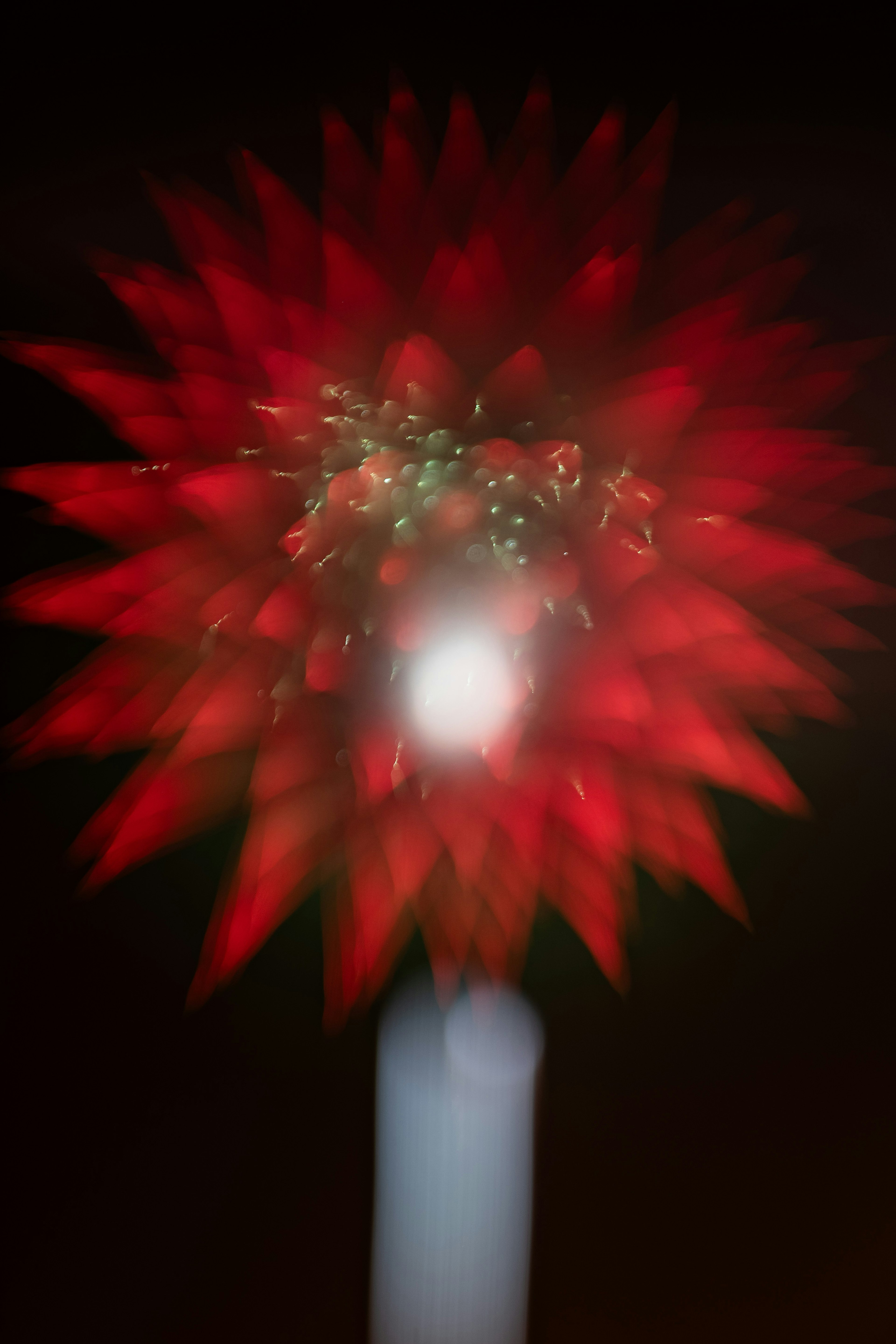 Immagine sfocata di una forma simile a un fiore rosso con luce brillante