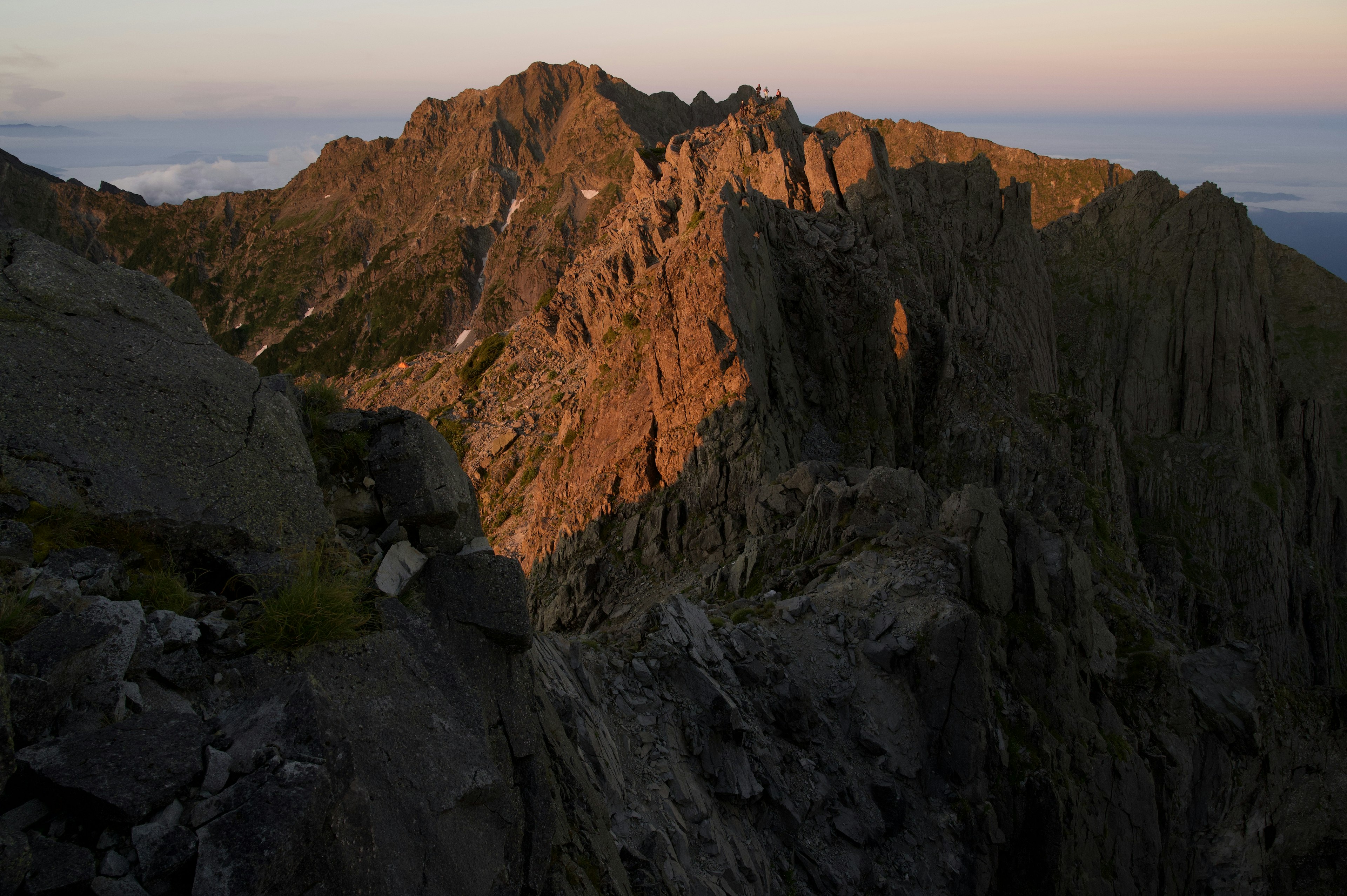 Punggungan gunung yang diterangi oleh cahaya matahari terbenam