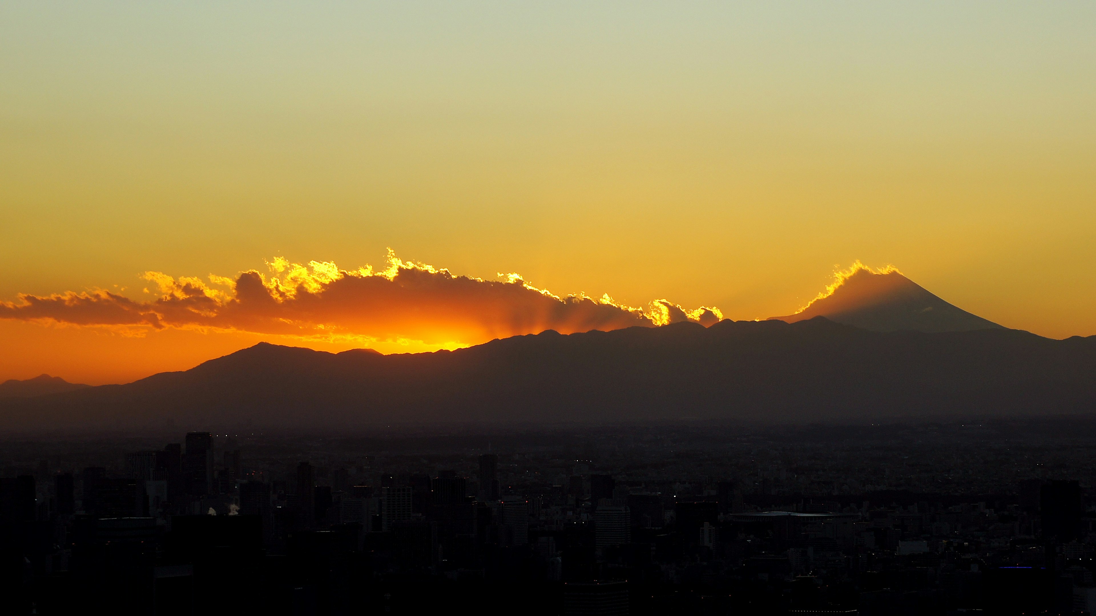 夕焼けの中でそびえる山々と雲のシルエット