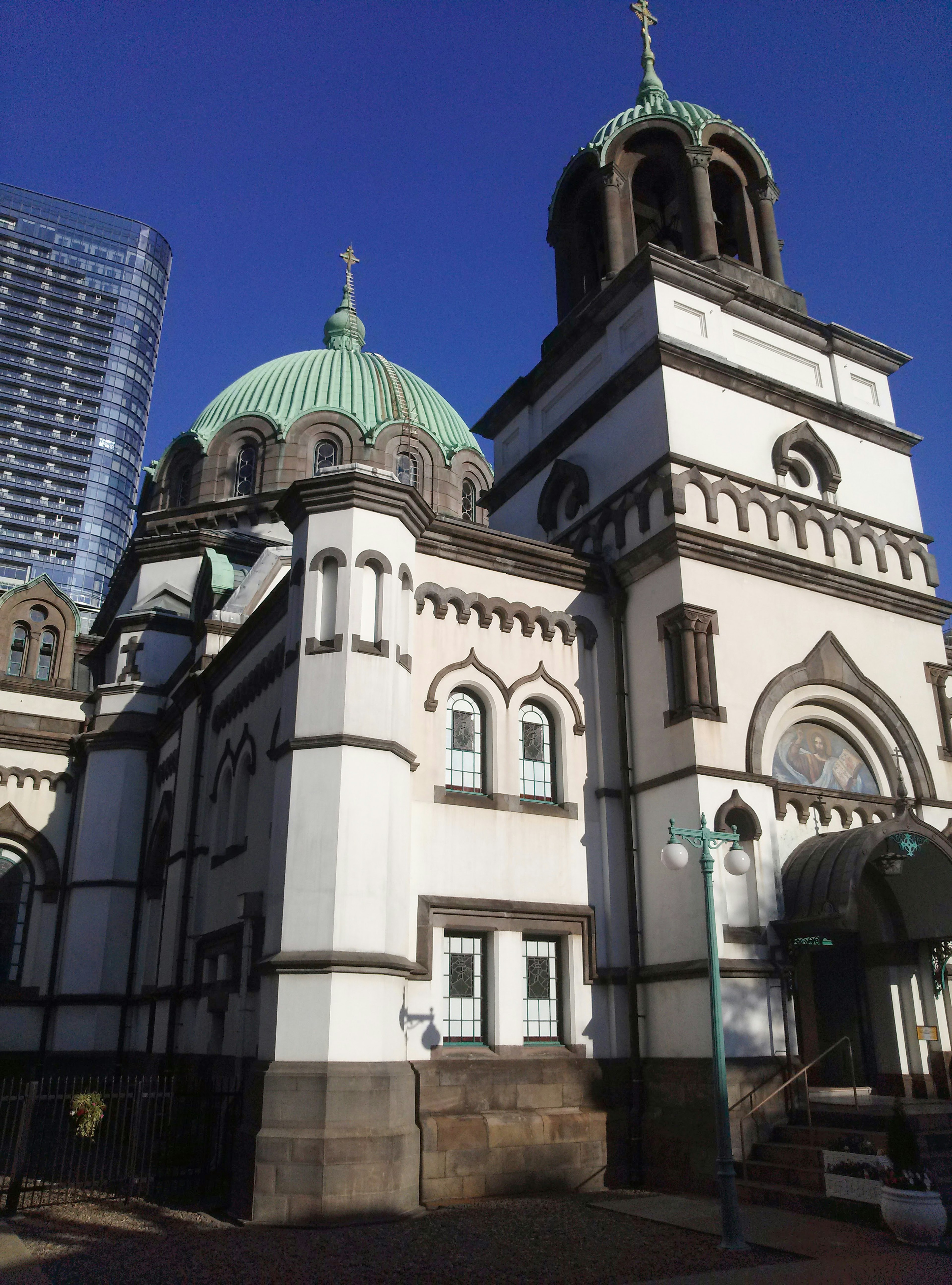 Photo of a church building with green domes and white façade