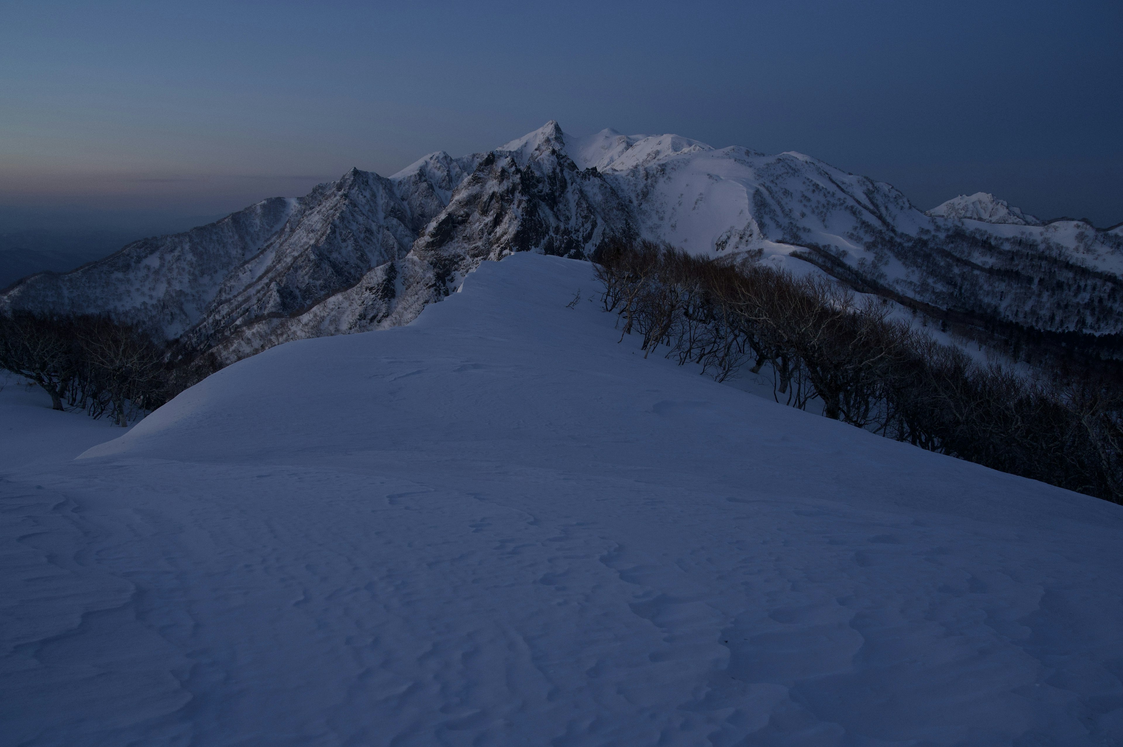 Paesaggio montano innevato con cielo crepuscolare