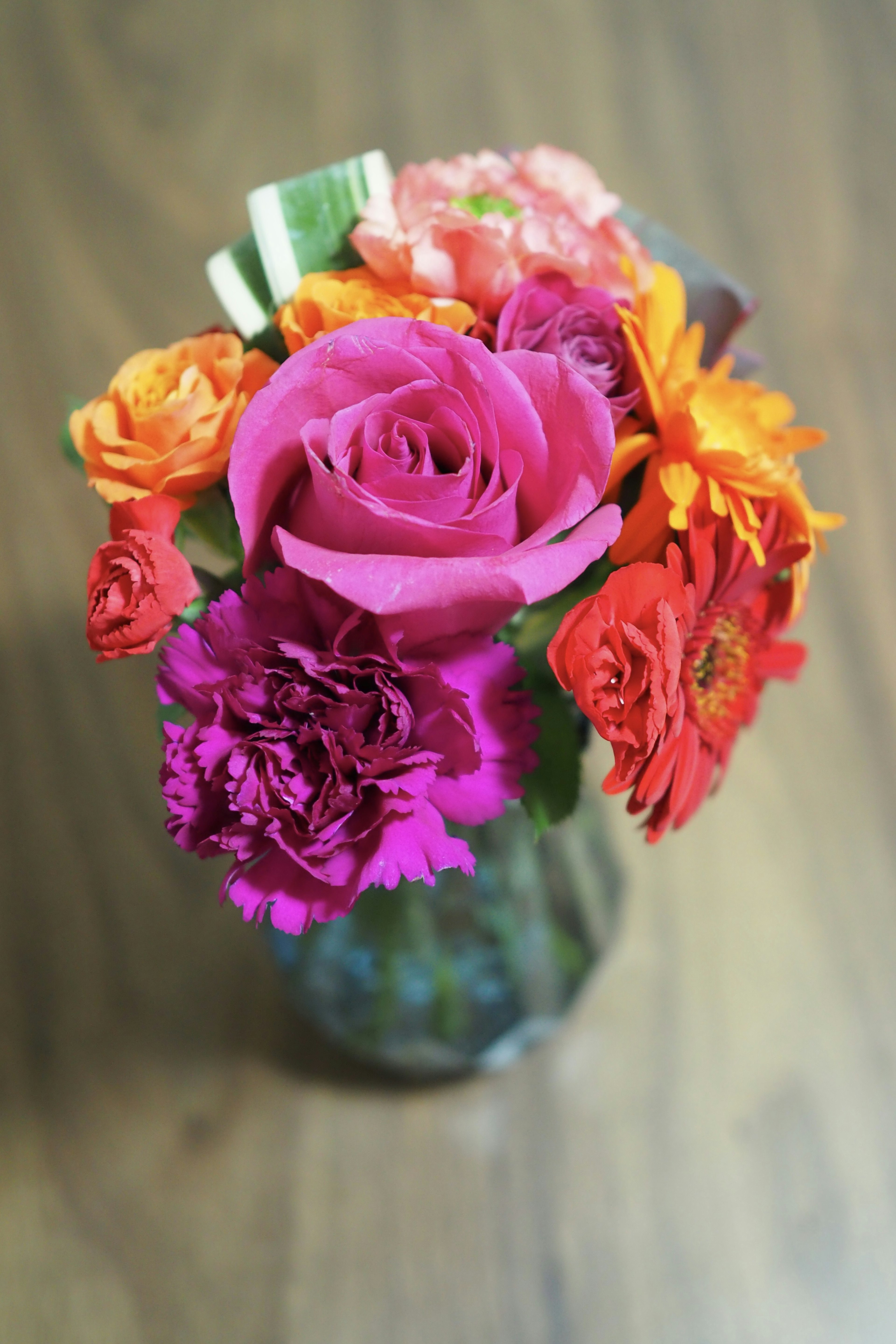 Bouquet berwarna-warni dalam vas dengan mawar marigold dan anyelir