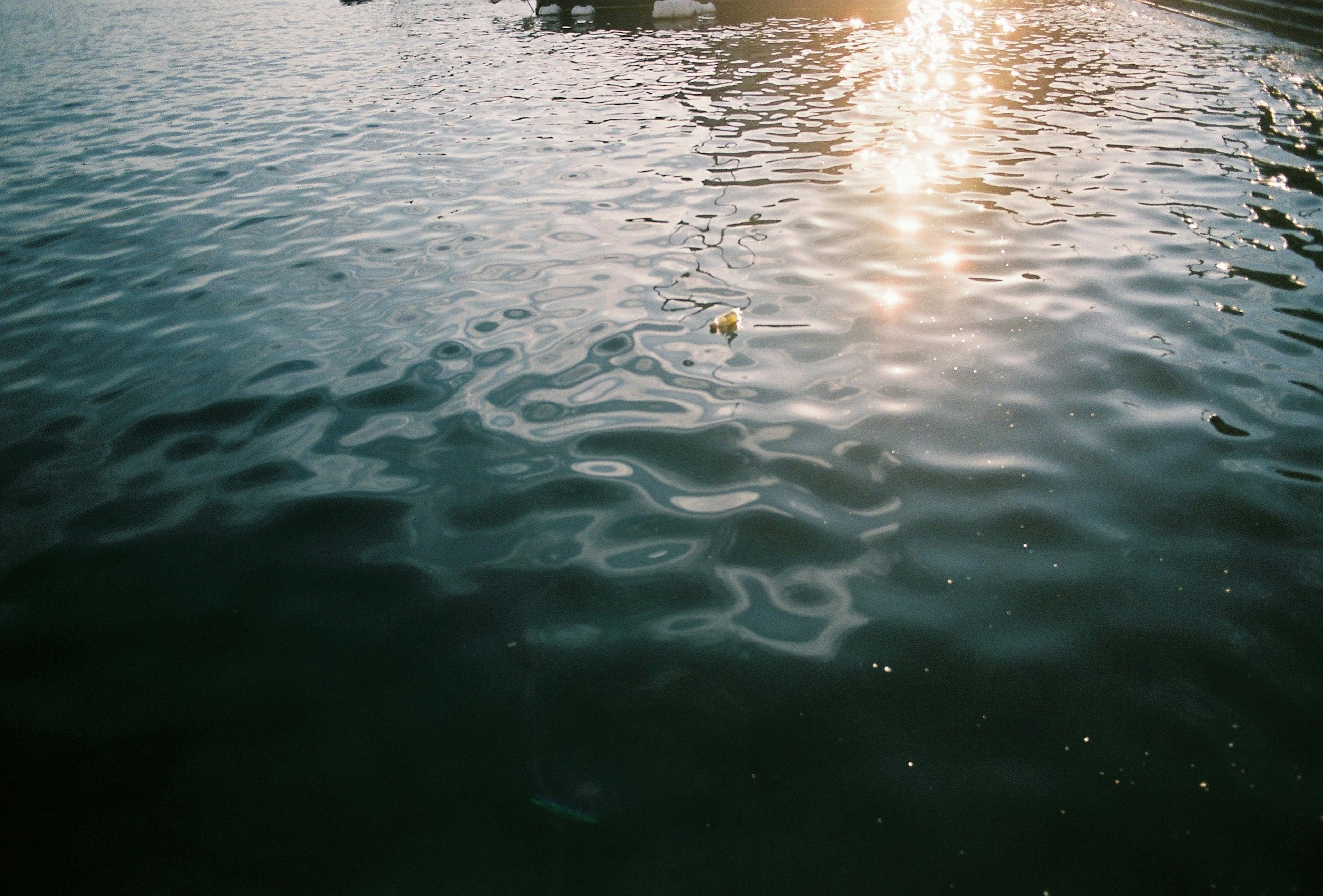 Superficie d'acqua increspata che riflette la luce del sole