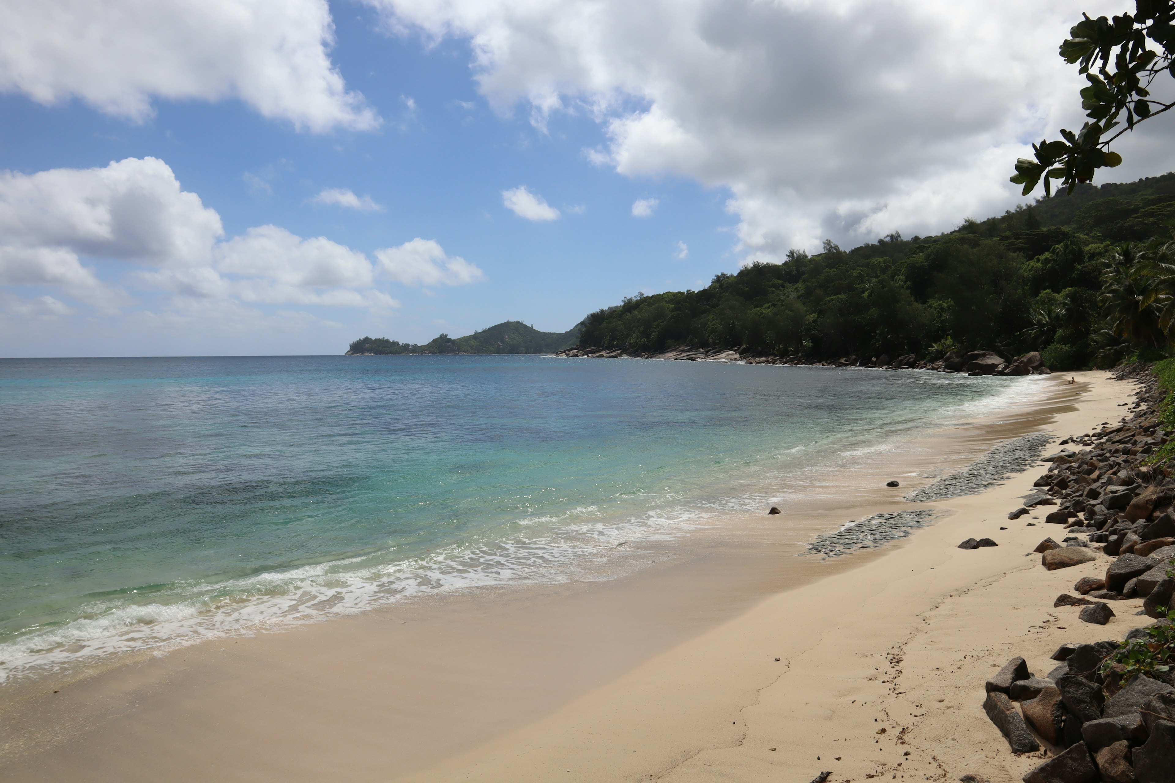 Vue de plage pittoresque avec océan bleu et sable blanc sous un ciel ensoleillé