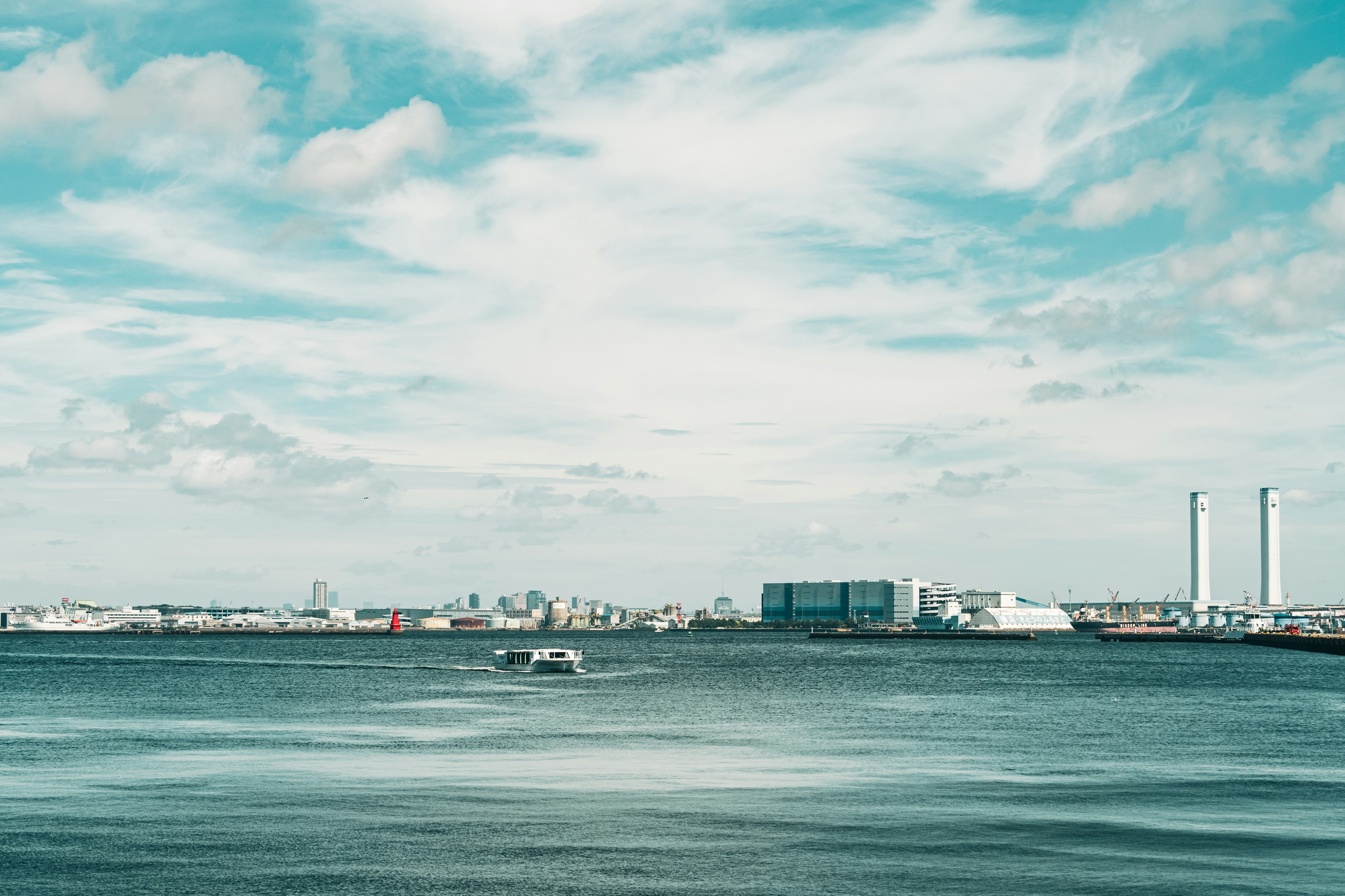 Scenic view of a harbor with blue waters and a cloudy sky