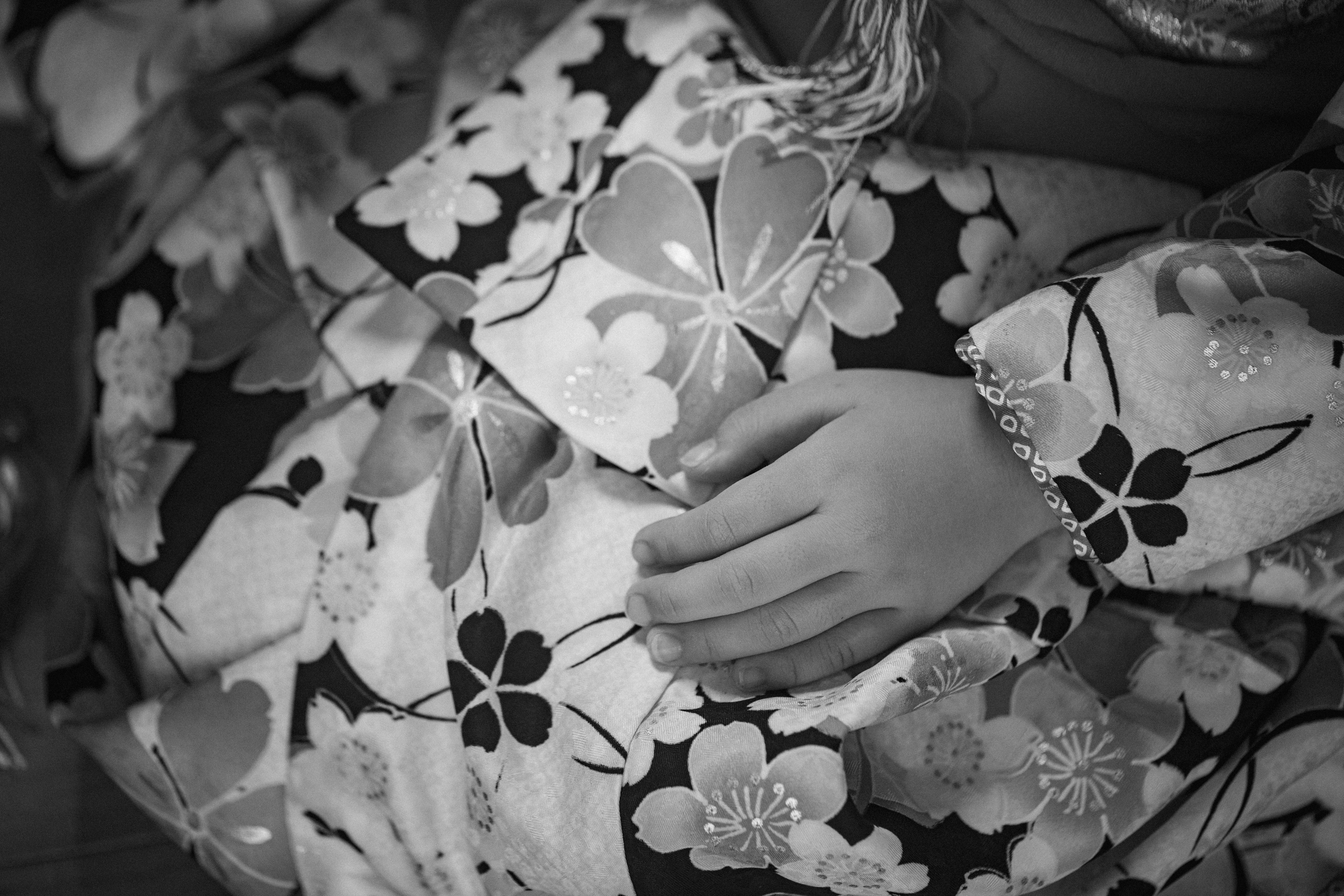 A hand resting on floral patterned fabric of a modern kimono