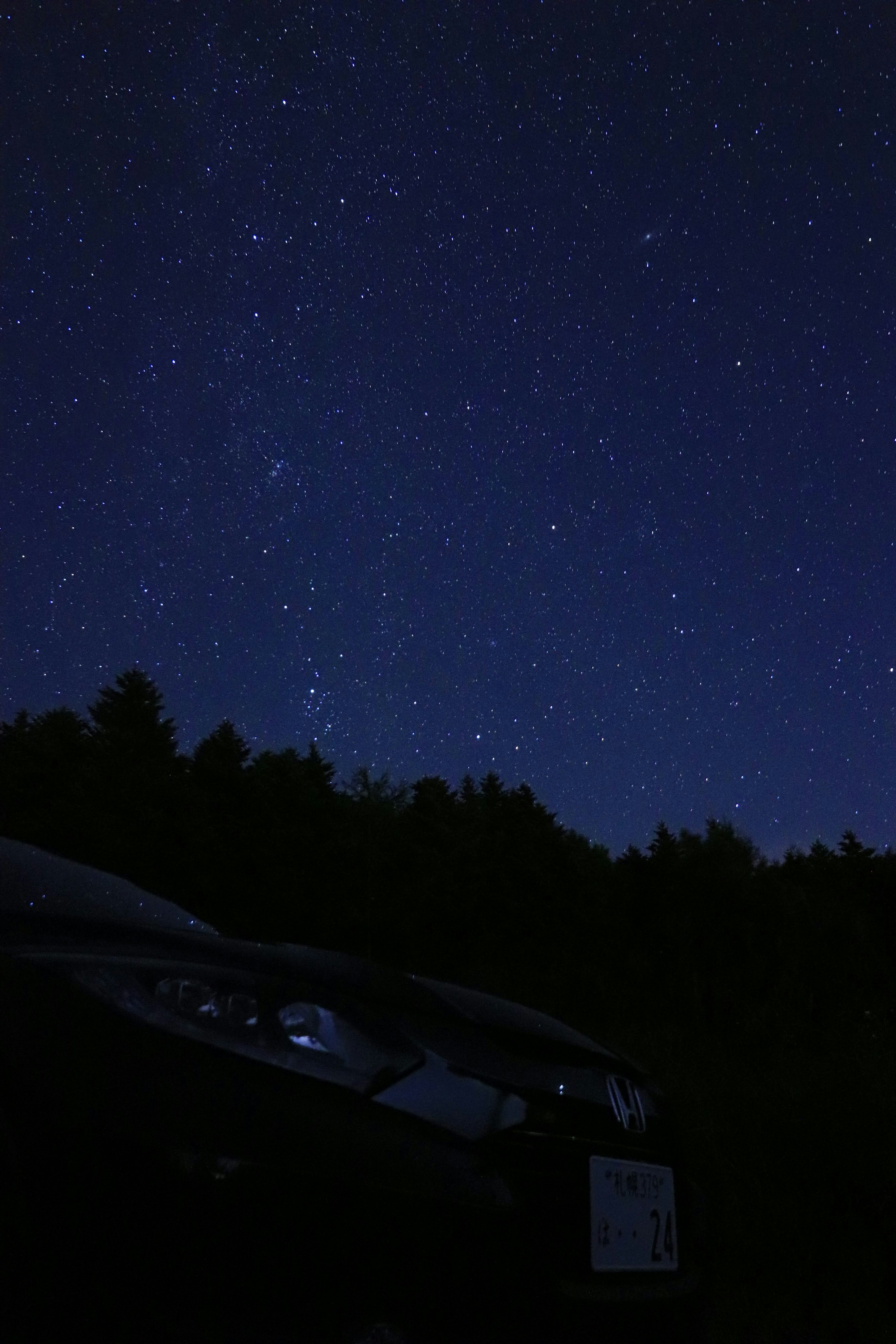 Night scene featuring a car under a starry sky