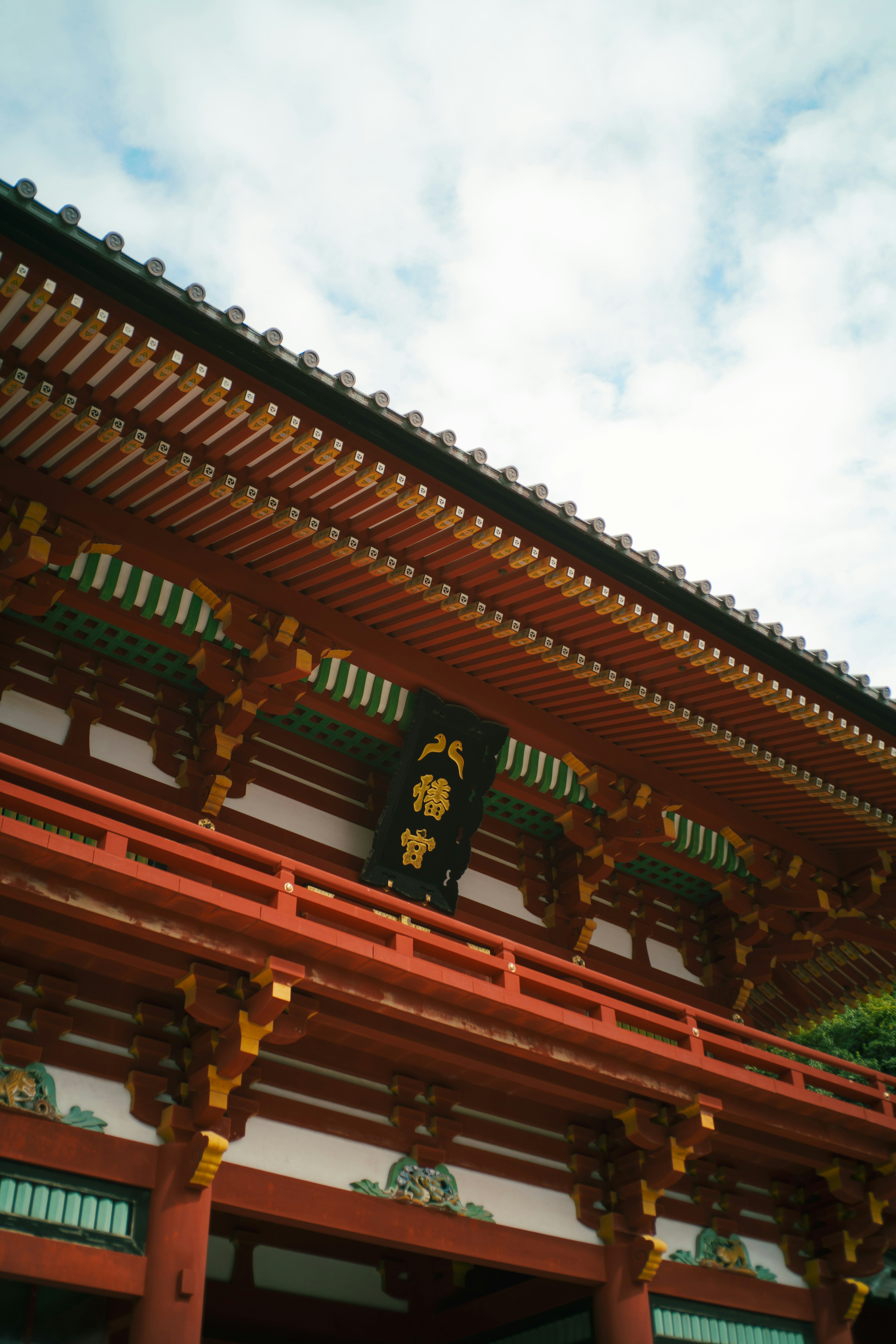 Eksterior kuil Jepang tradisional dengan struktur merah dan langit biru