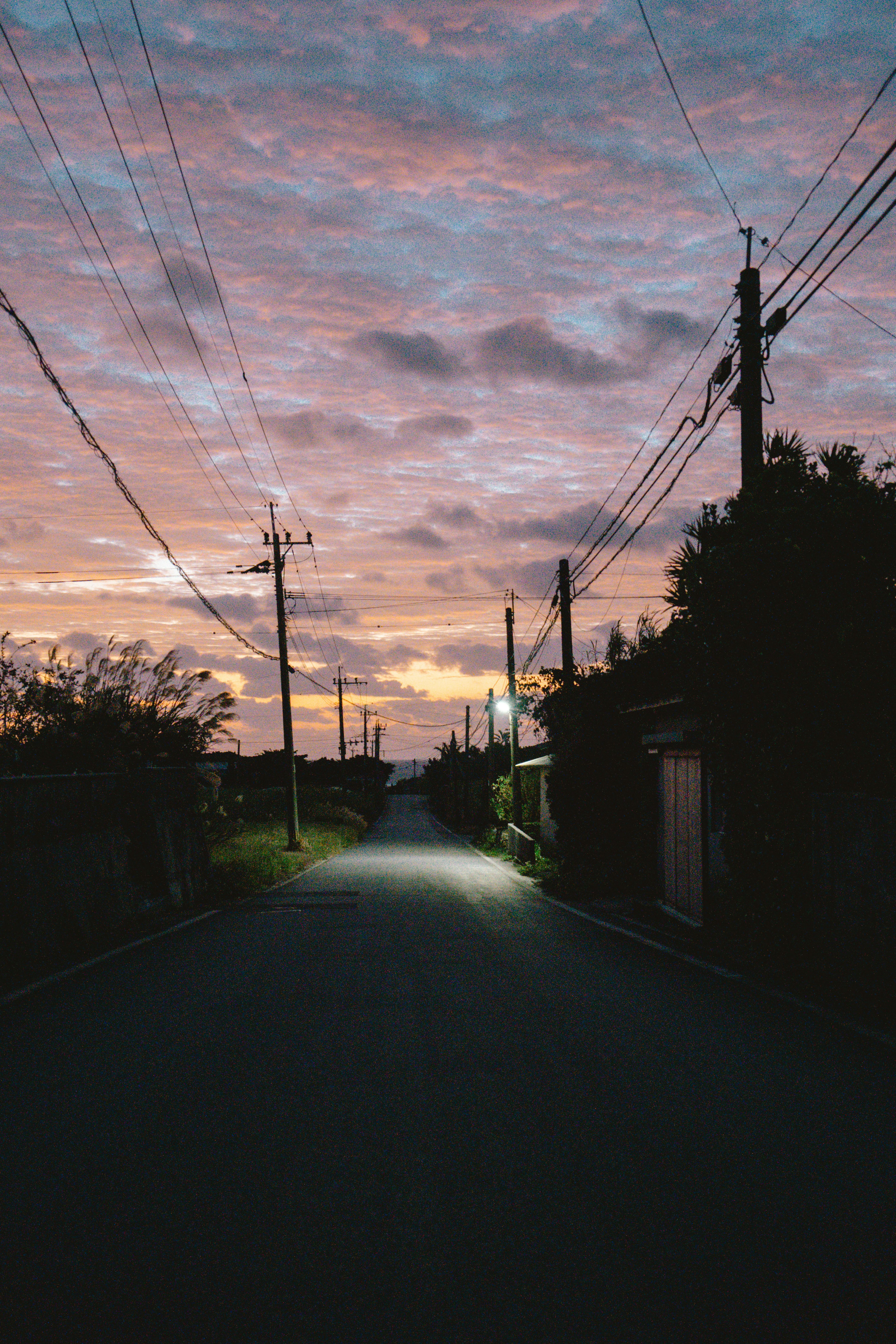 A quiet street scene surrounded by a sunset sky