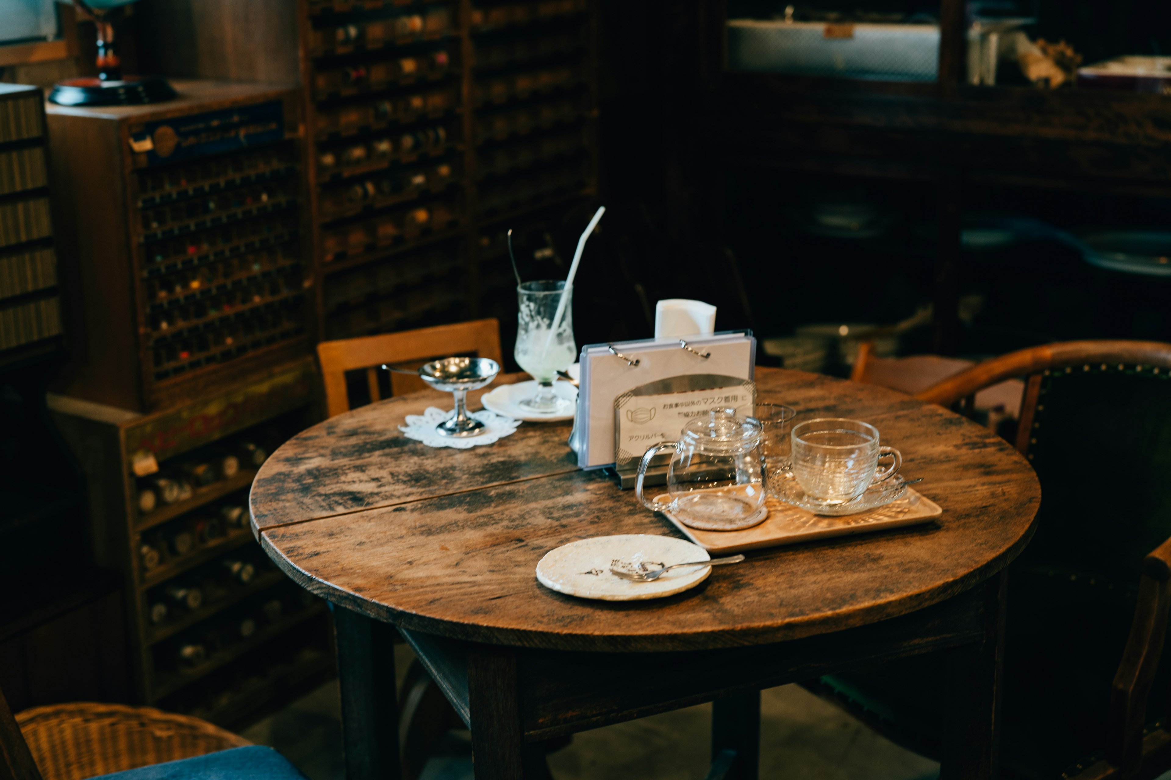 Wooden table with glasses and a plate in a cafe setting