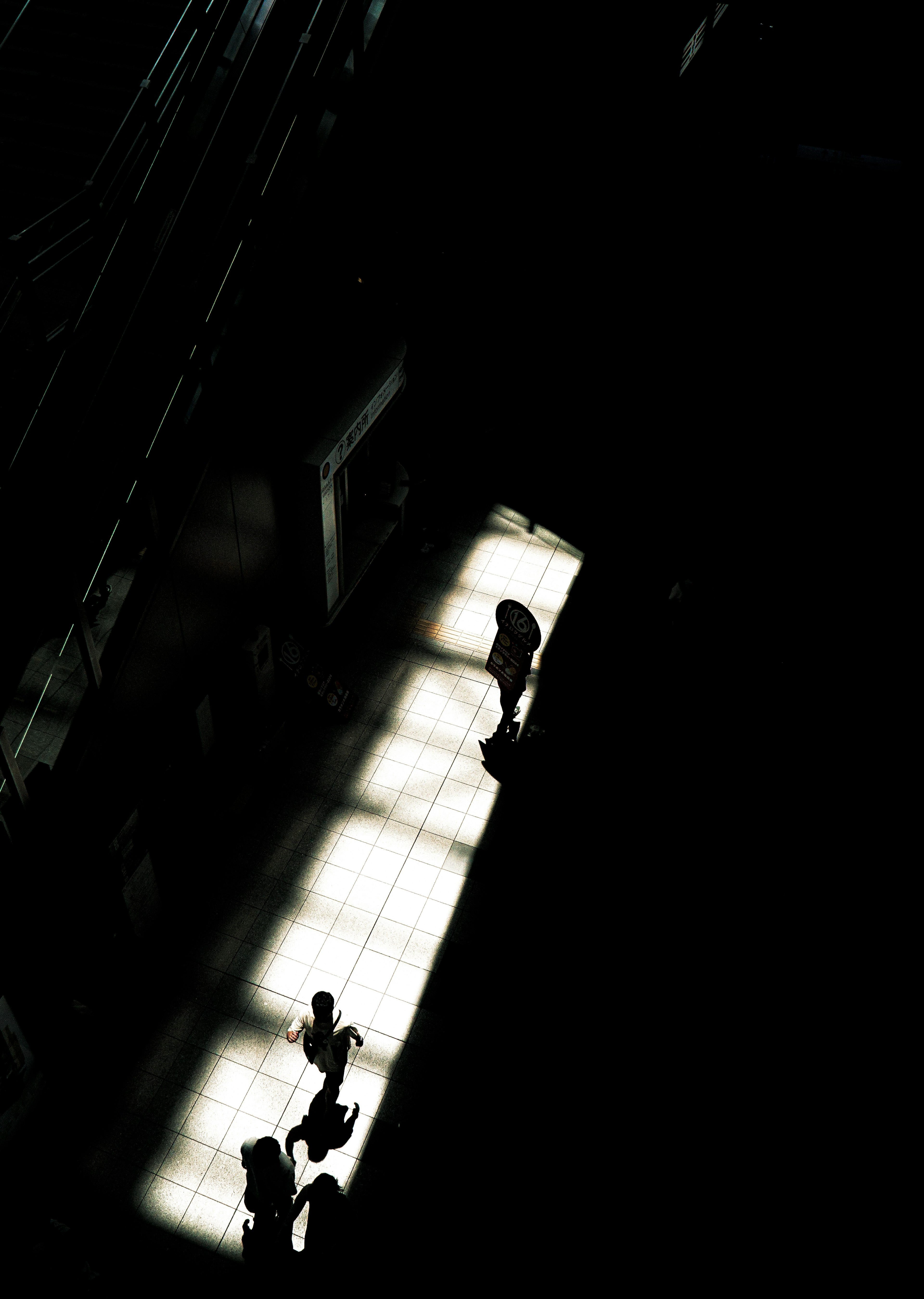 Silhouettes of people on a light path against a dark background