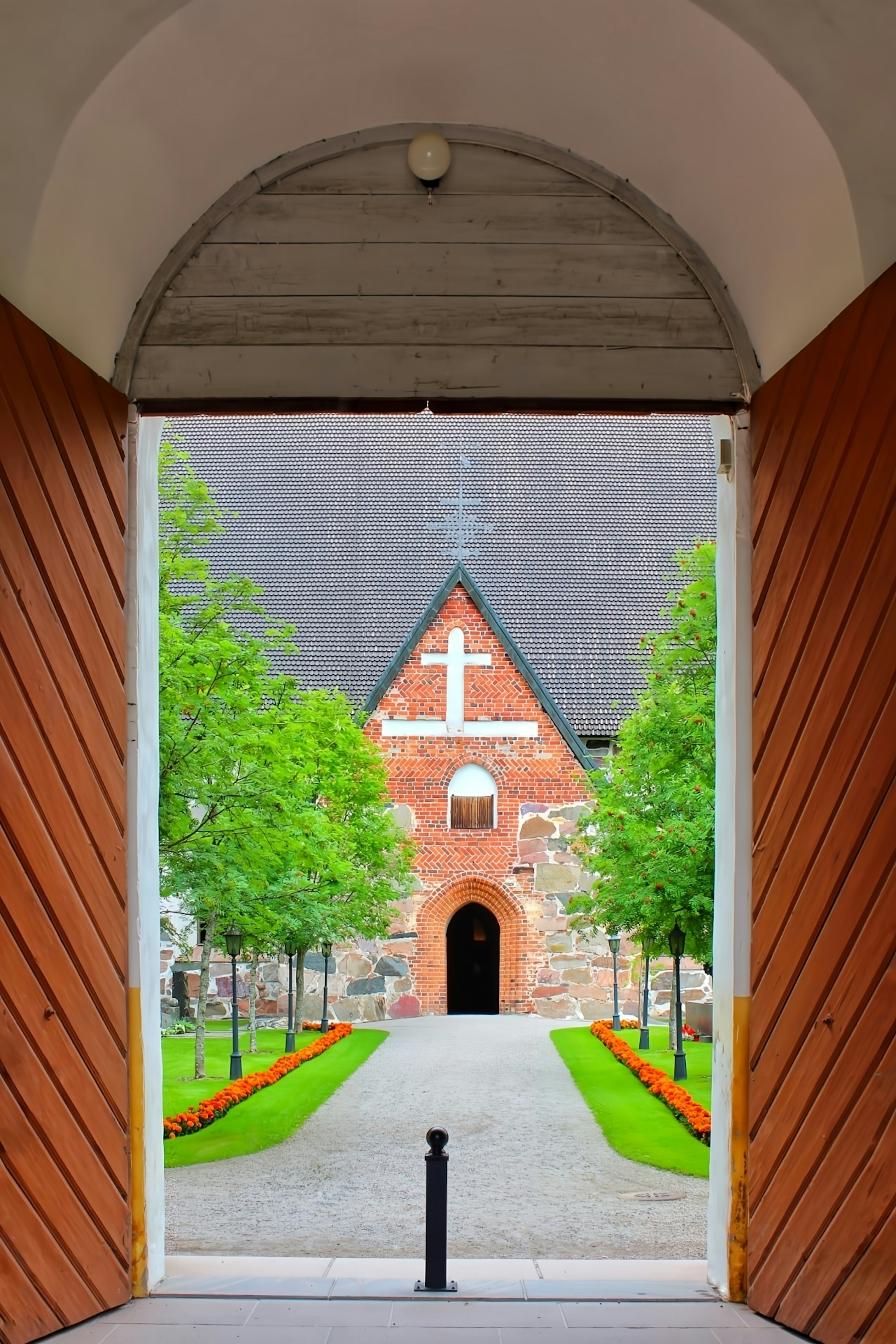 A beautiful entrance to a church surrounded by green trees