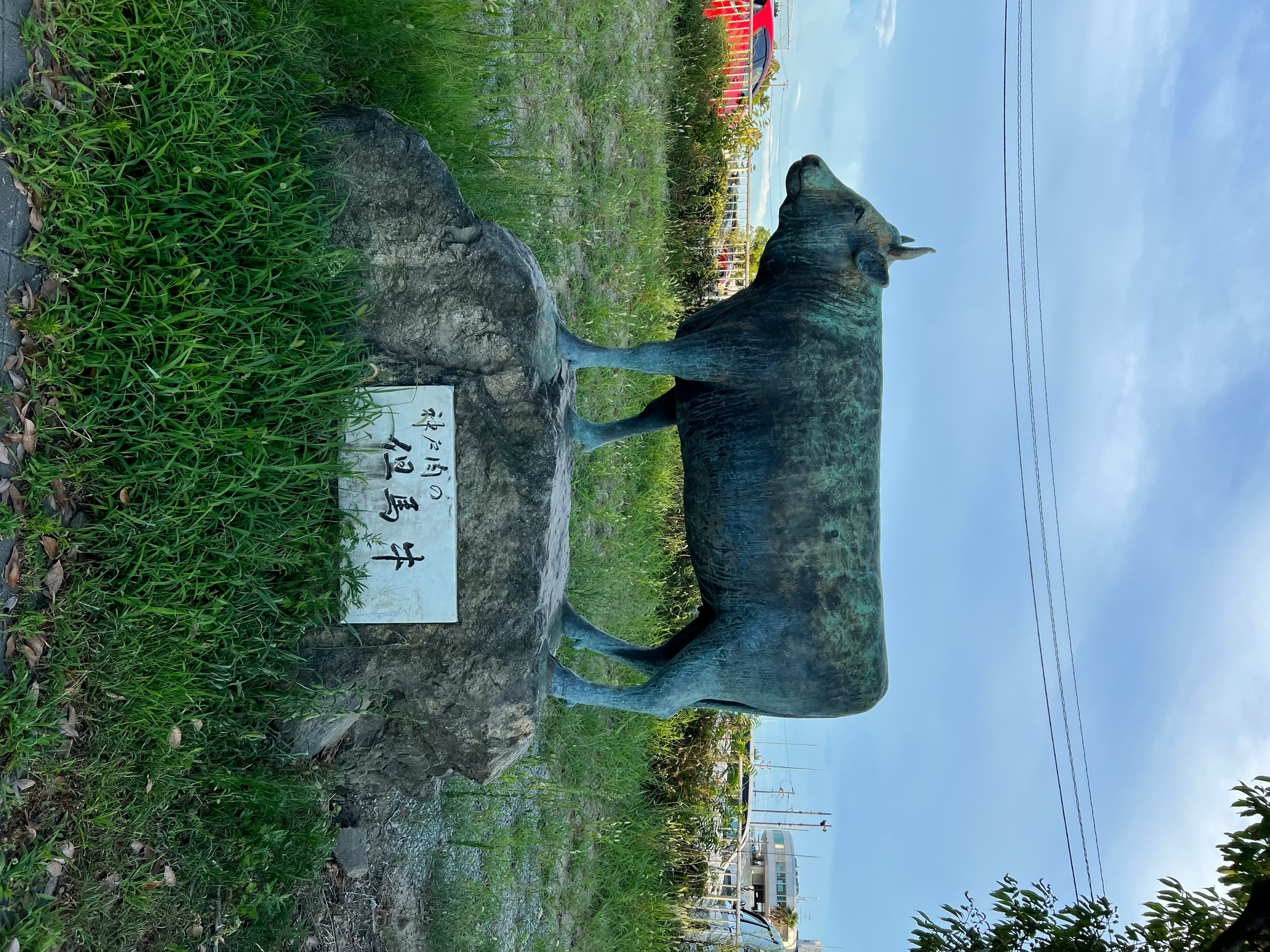 Una escultura de vaca de pie entre la hierba