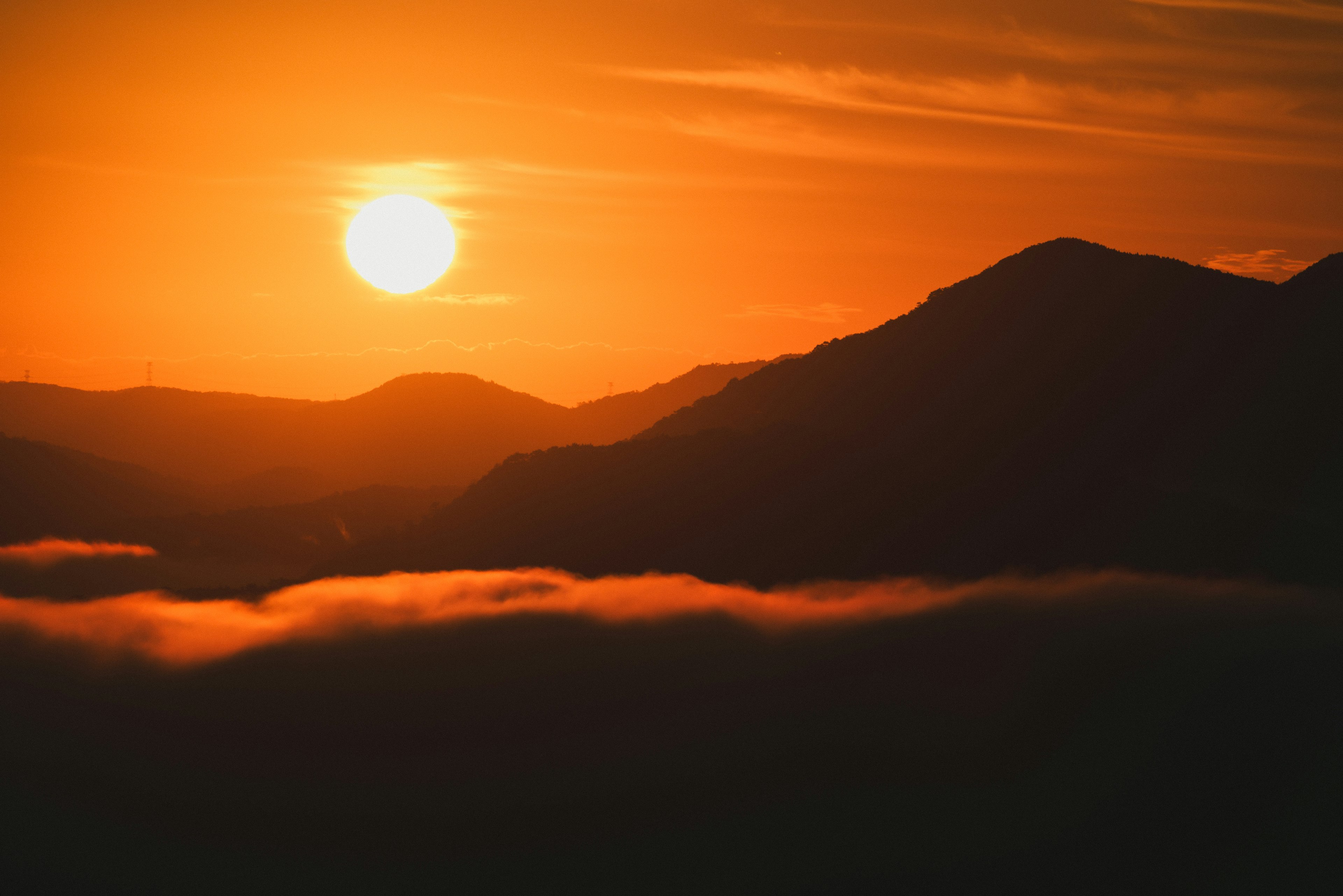 활기찬 오렌지색 석양을 배경으로 한 산의 실루엣