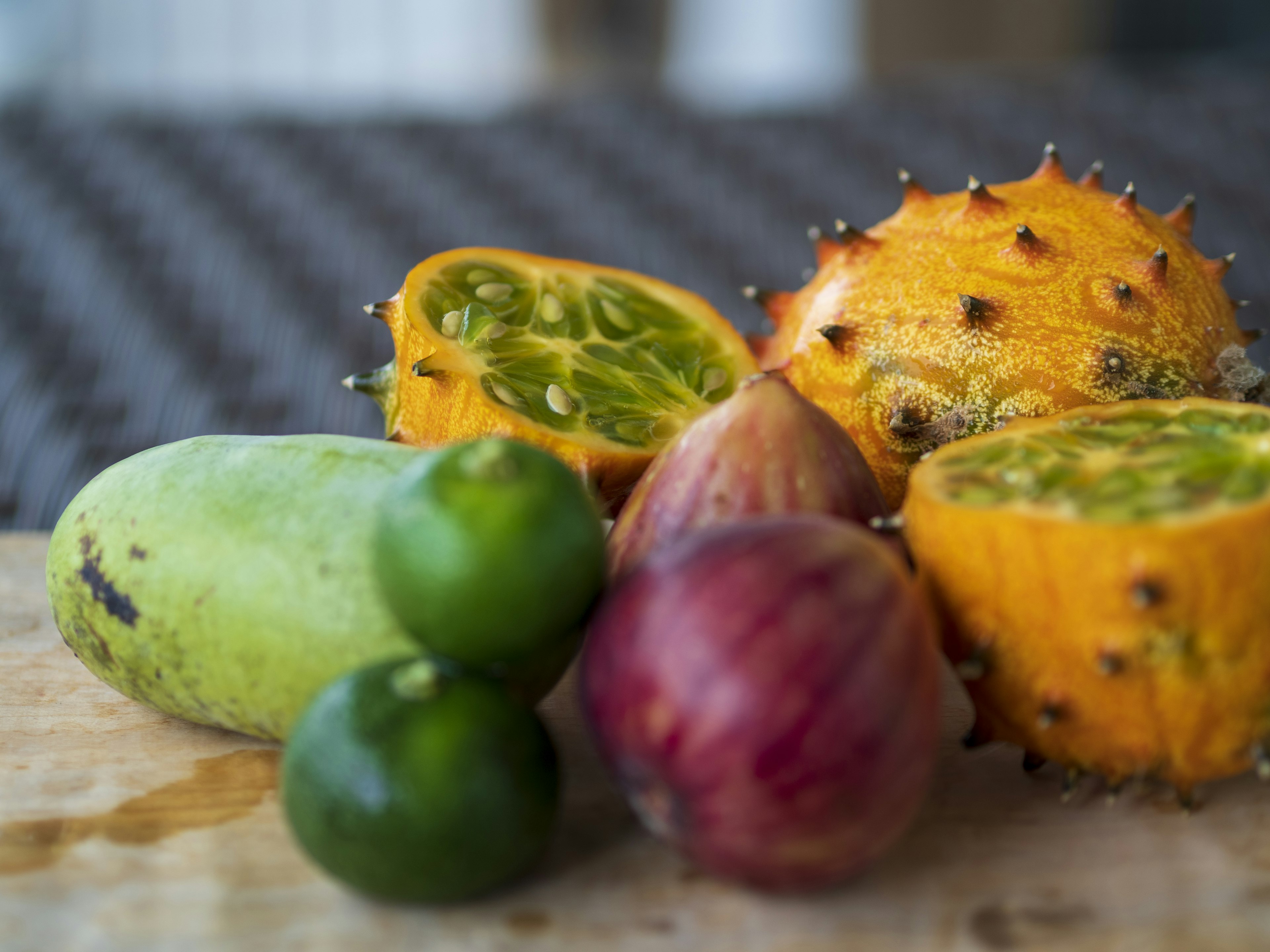 Colorful assortment of fruits green mango spiky yellow fruit red onion and lime