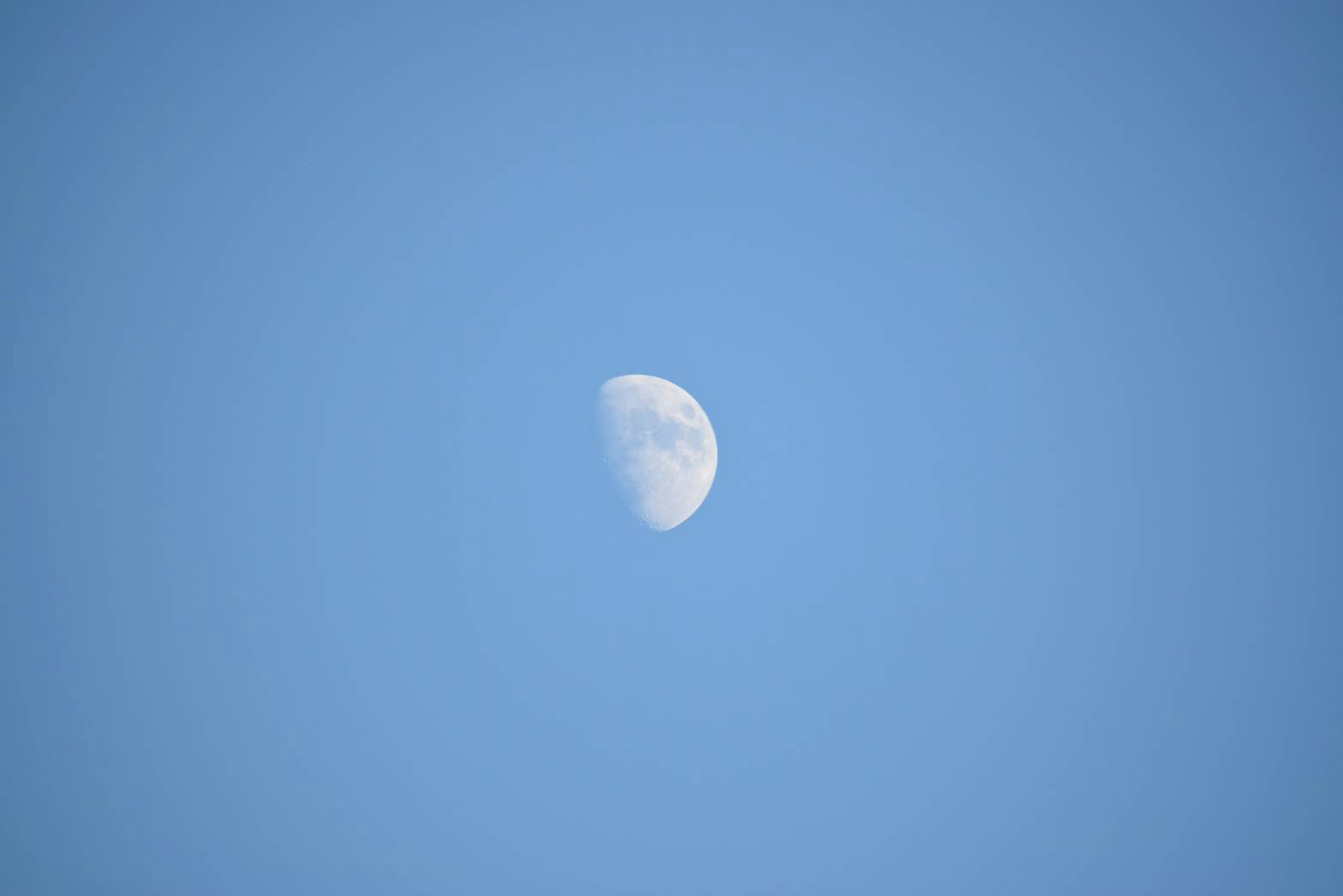 Hermosa vista de una luna creciente en el cielo azul