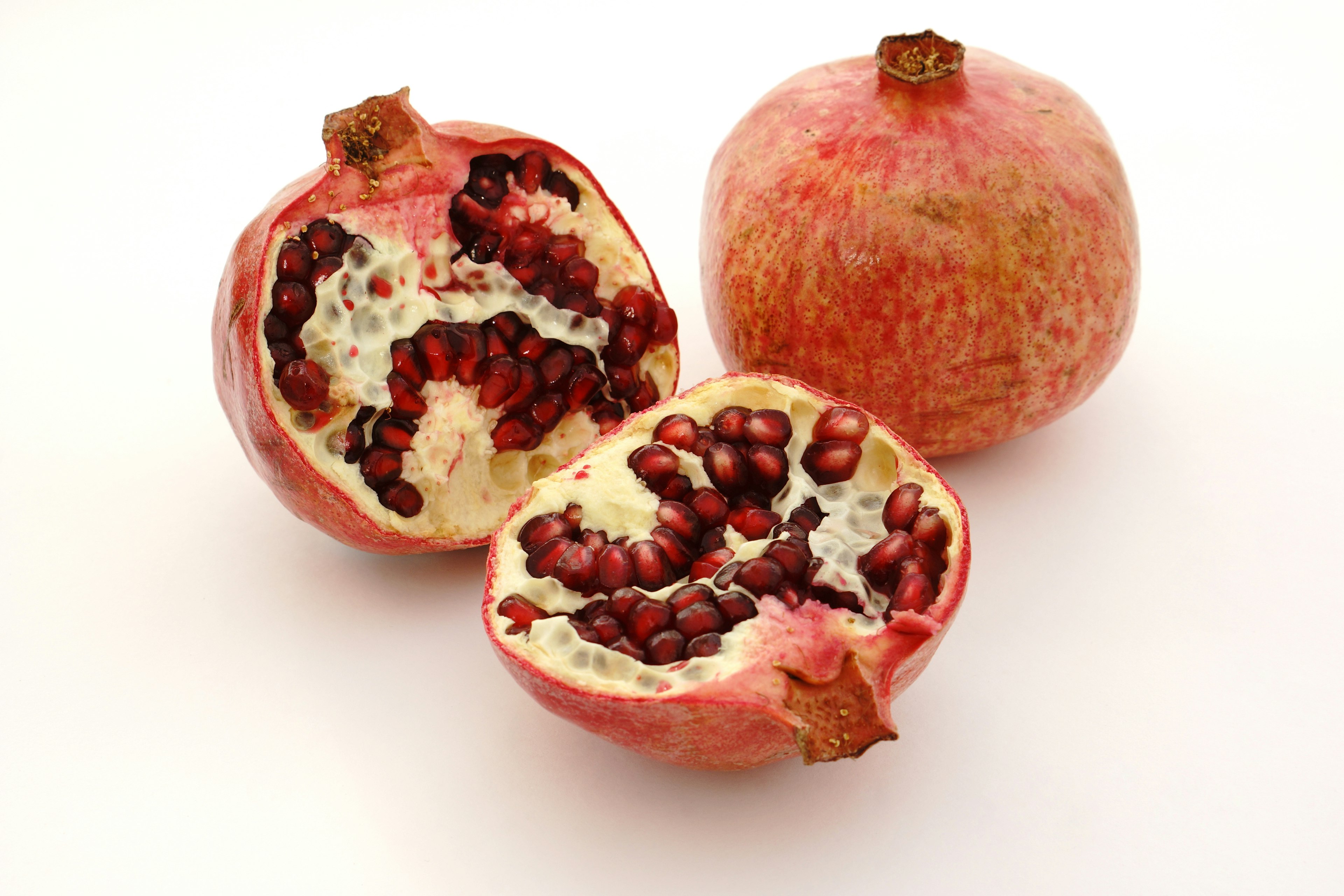 Cut pomegranate fruit showcasing its red seeds and inner structure