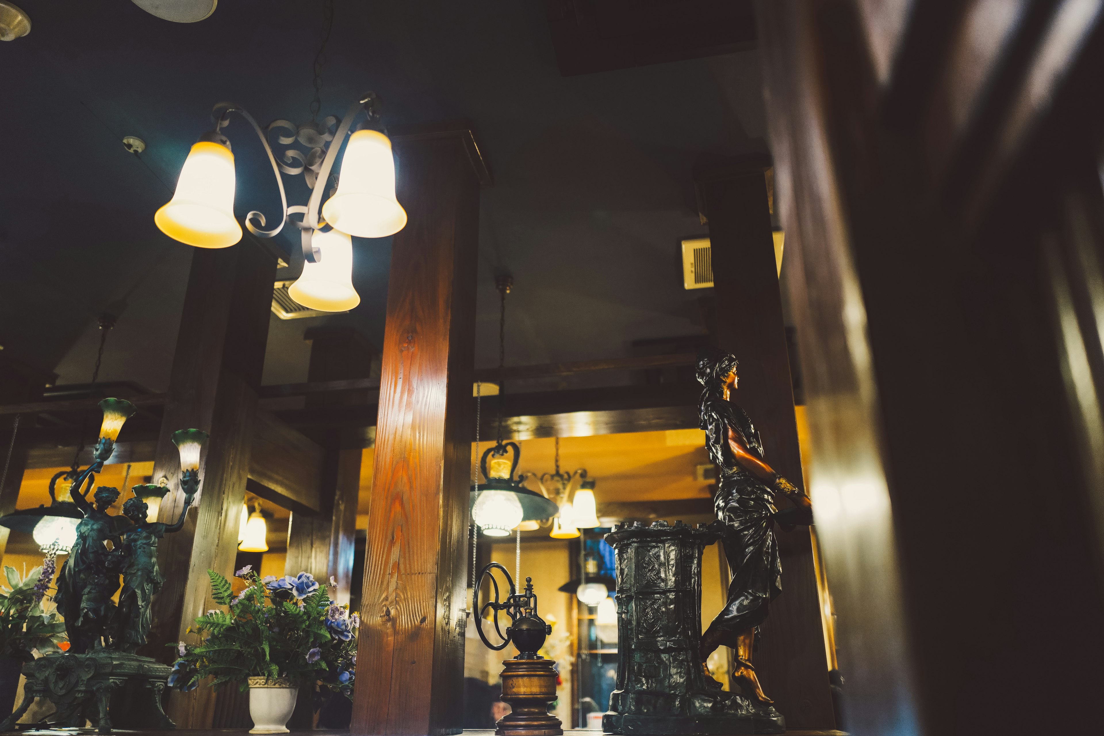 Interior de un restaurante tenuemente iluminado con lámparas y esculturas