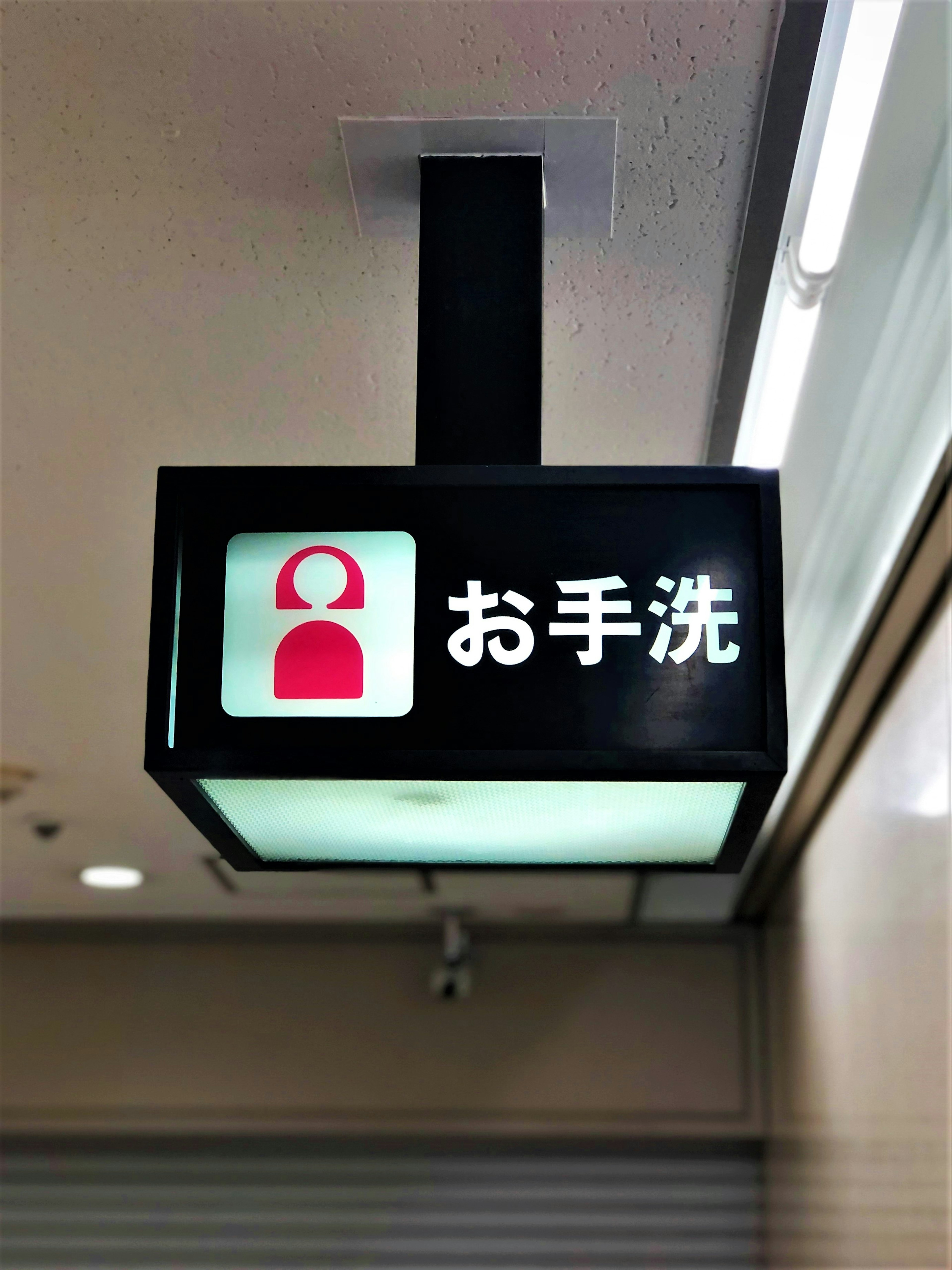 Sign indicating hand washing with a red icon and Japanese text