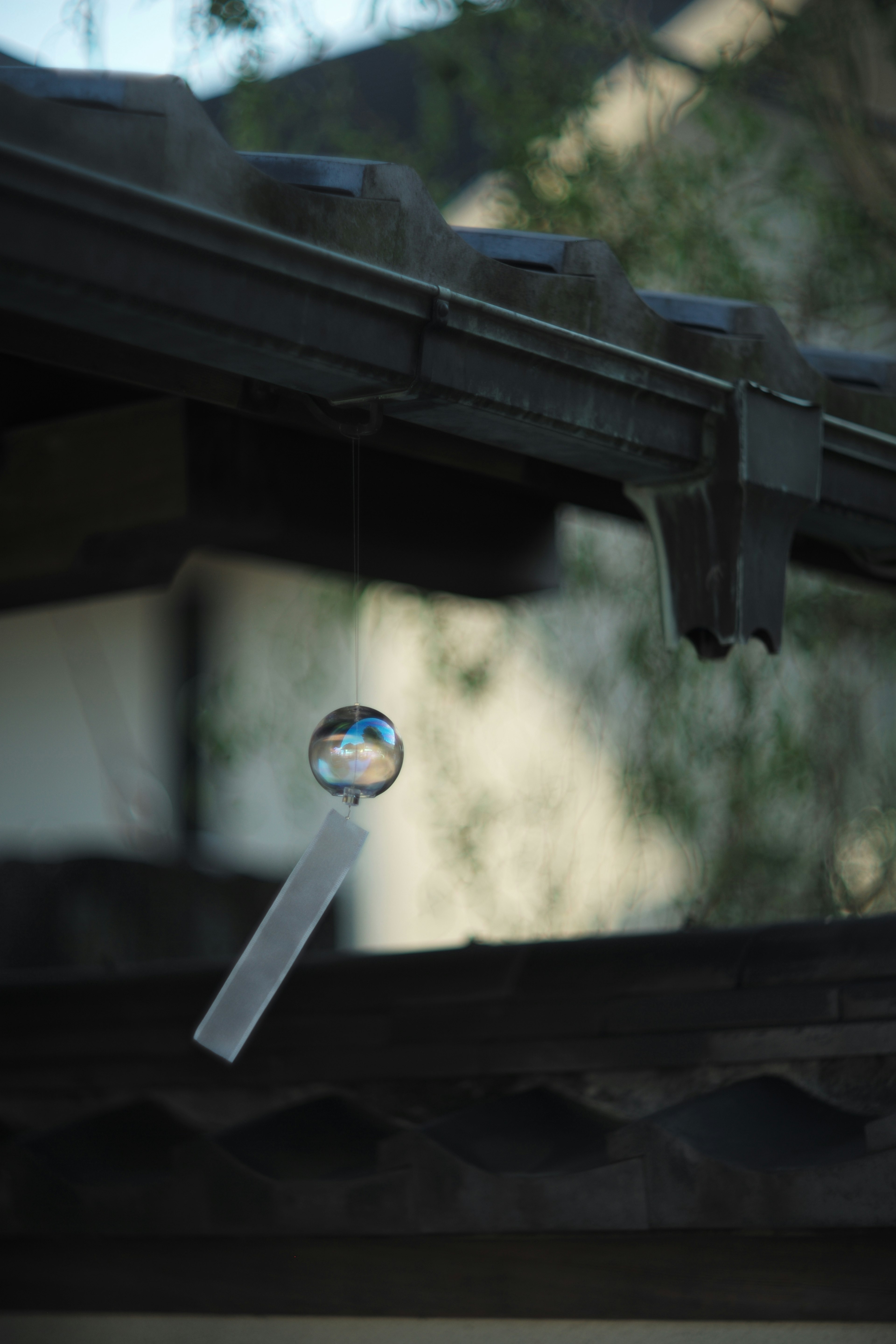 Wind chime hanging from a rooftop