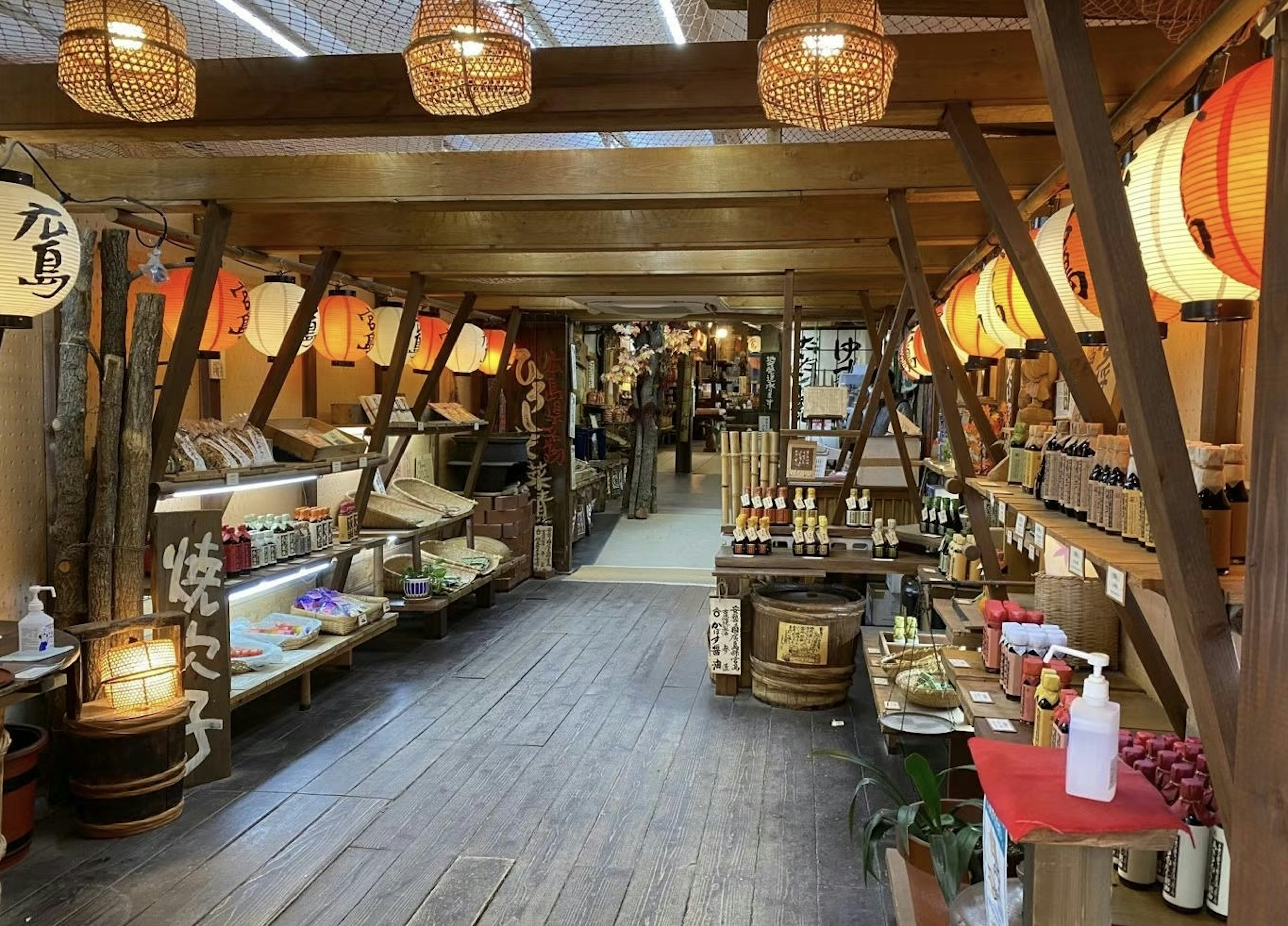 Vista interior de un mercado con estructuras de madera y luz cálida Las tiendas exhiben productos hechos a mano y decoraciones