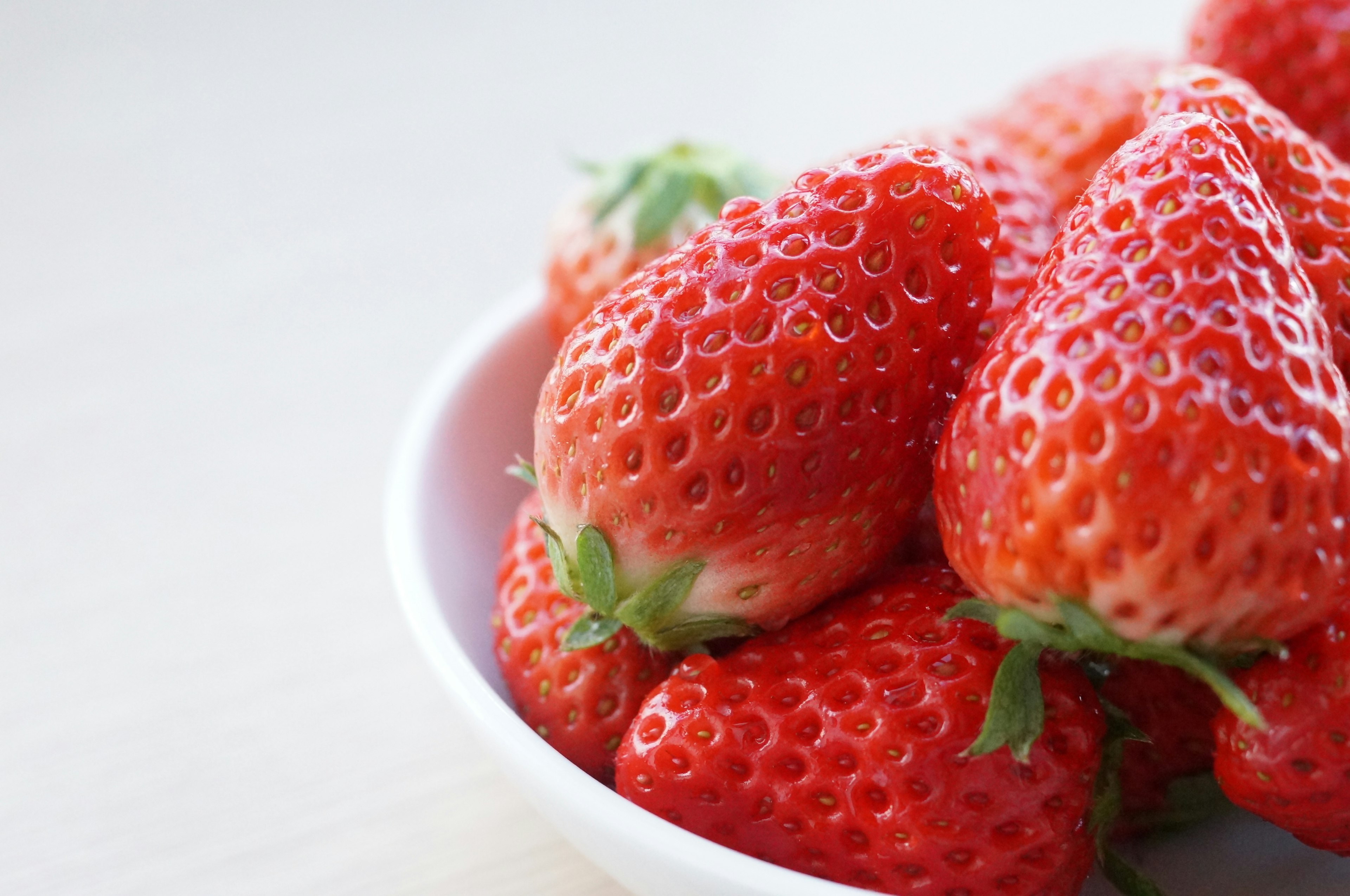 Fresh strawberries piled in a white bowl