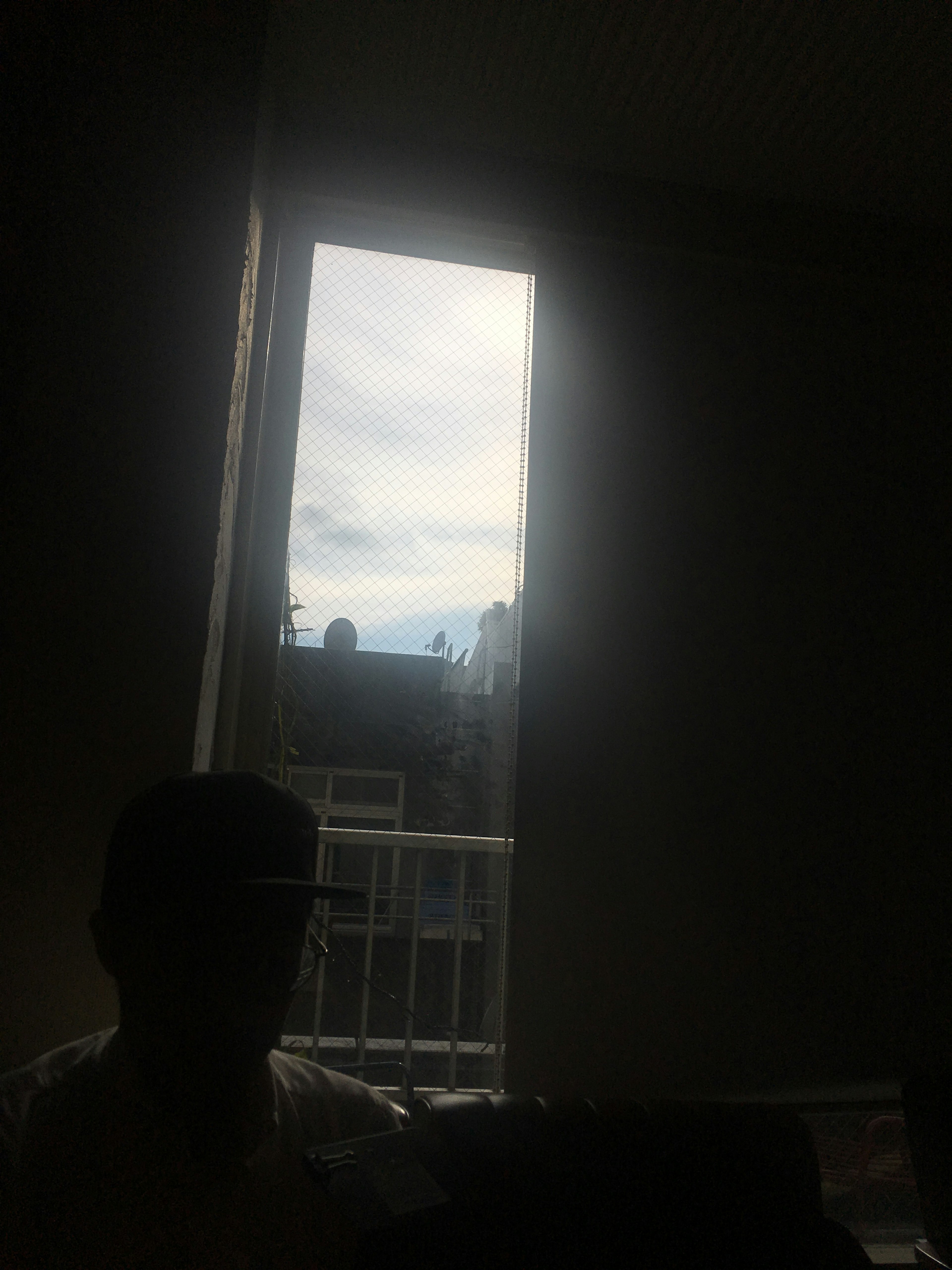 Dimly lit room with a window showing cloudy sky