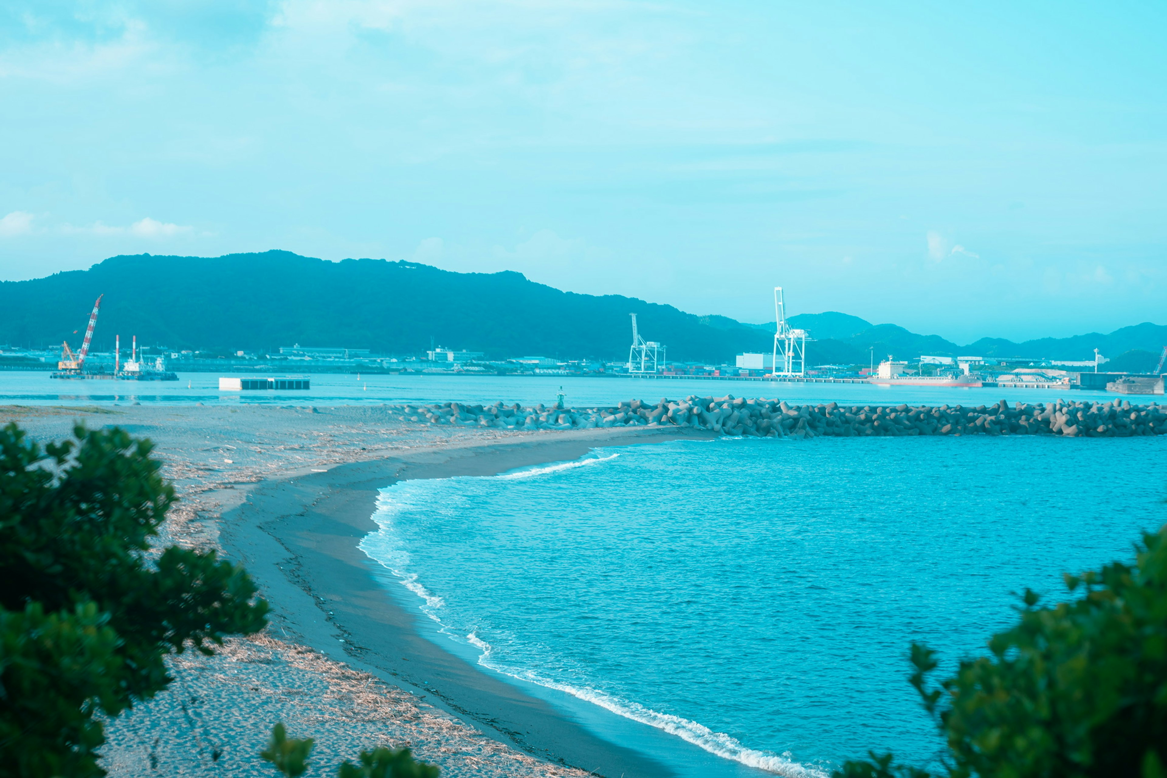 青い海と山々が見える港の風景