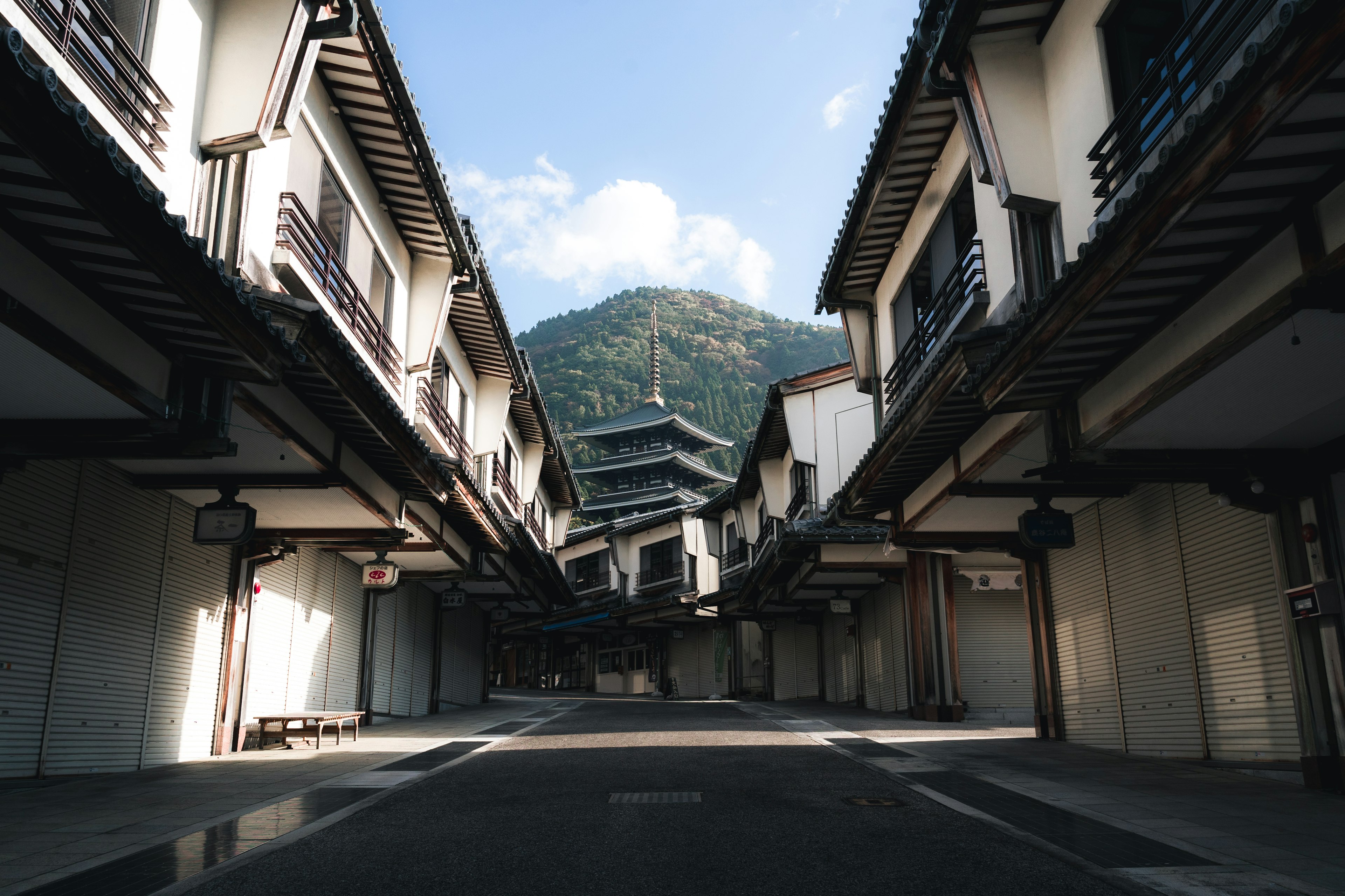 Rue tranquille bordée de bâtiments traditionnels avec une vue sur la montagne