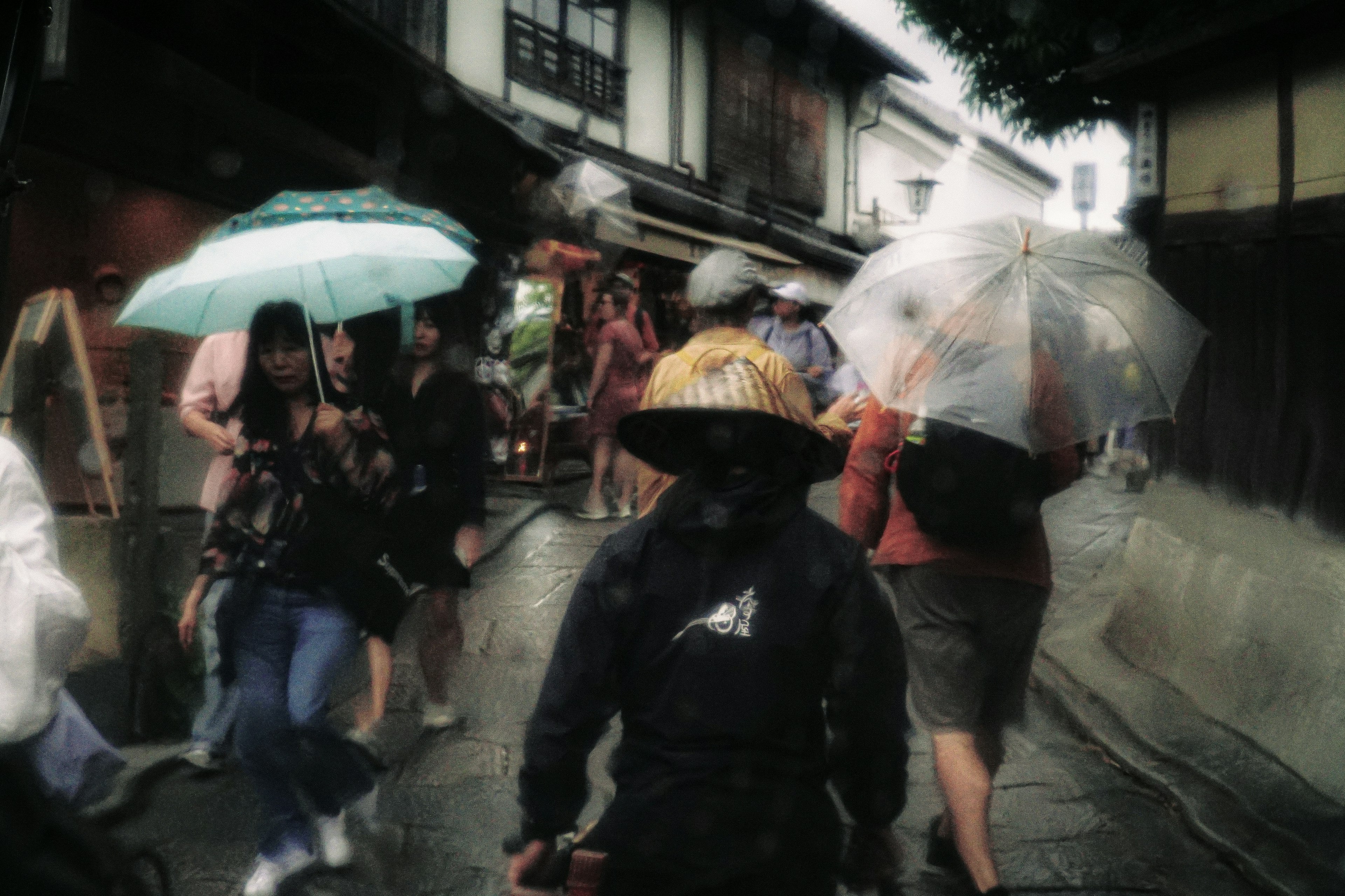 Multitud de personas caminando bajo la lluvia con paraguas coloridos