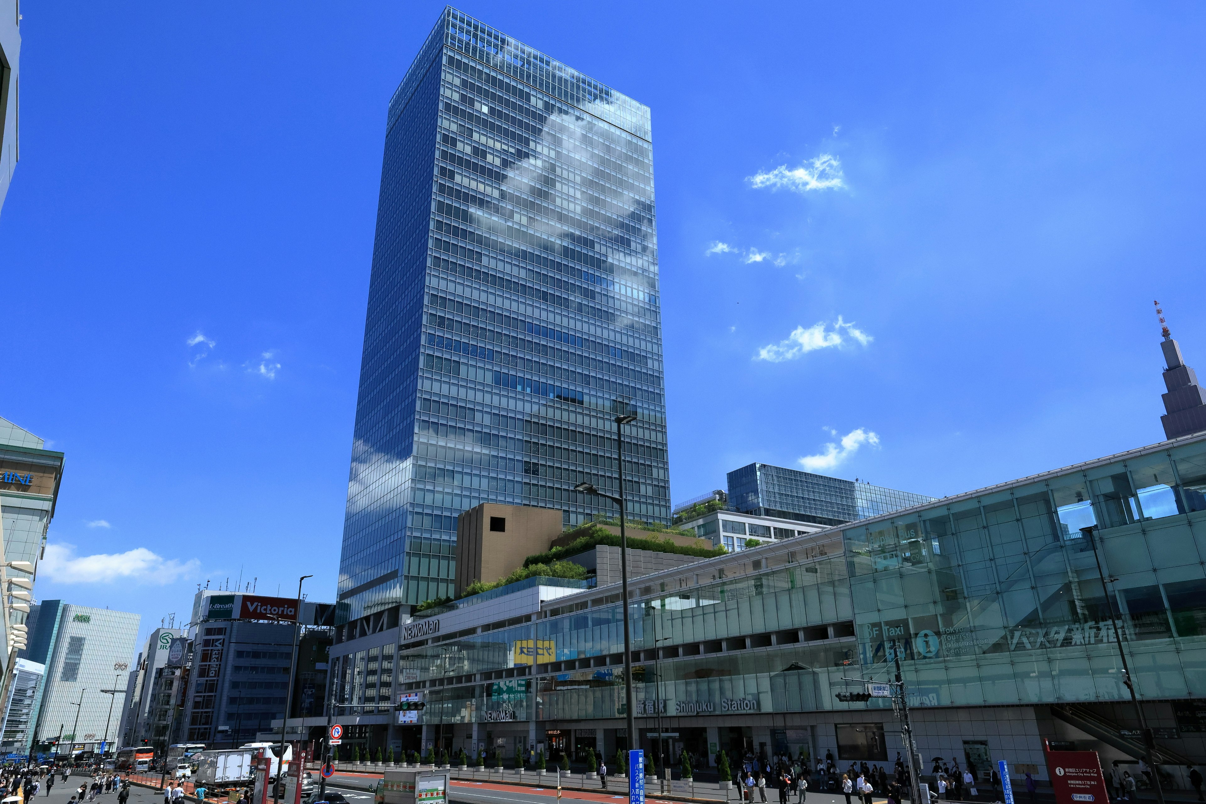 Rascacielos moderno contra un cielo azul cerca de una estación de tren