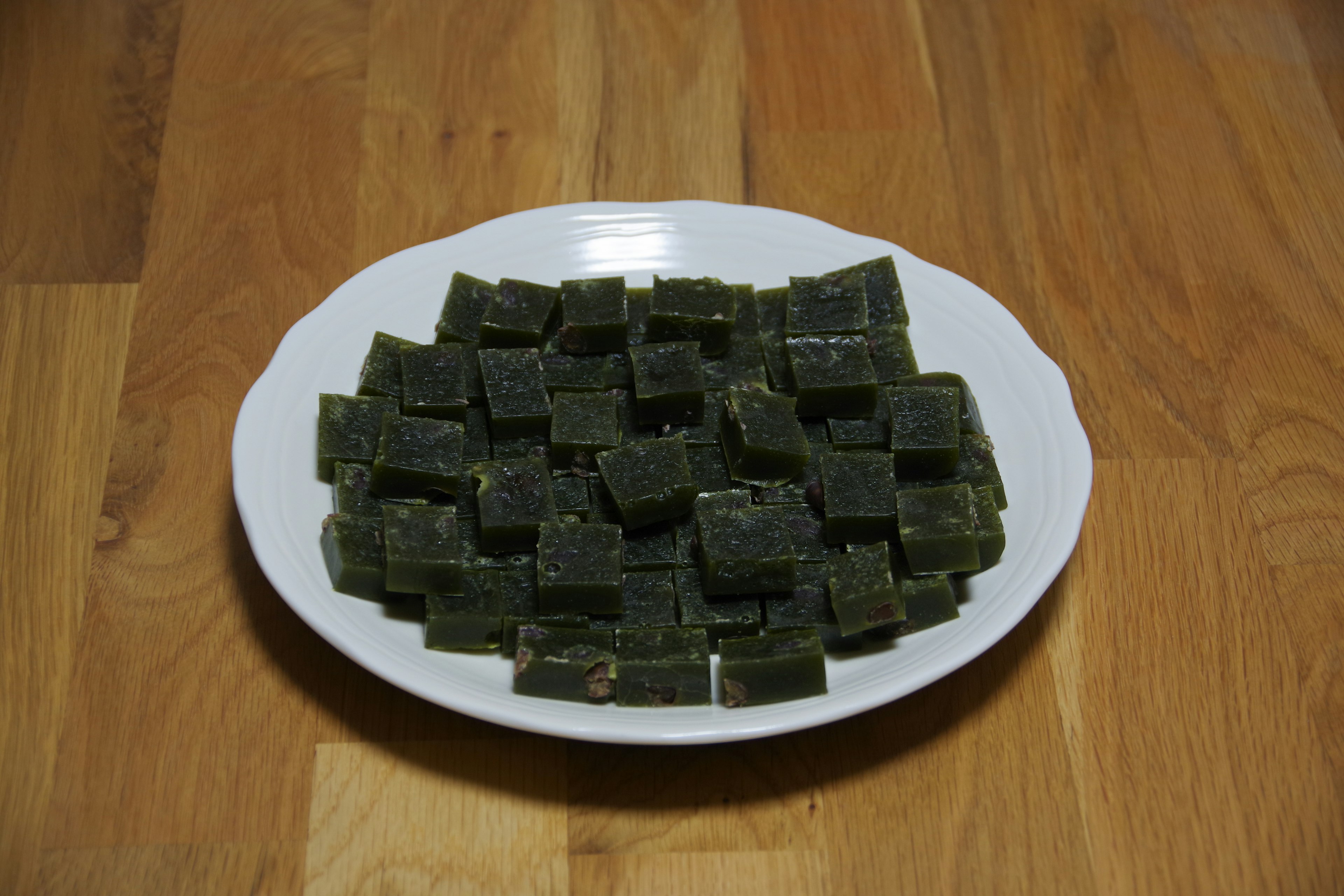 Green jelly dessert arranged neatly on a white plate