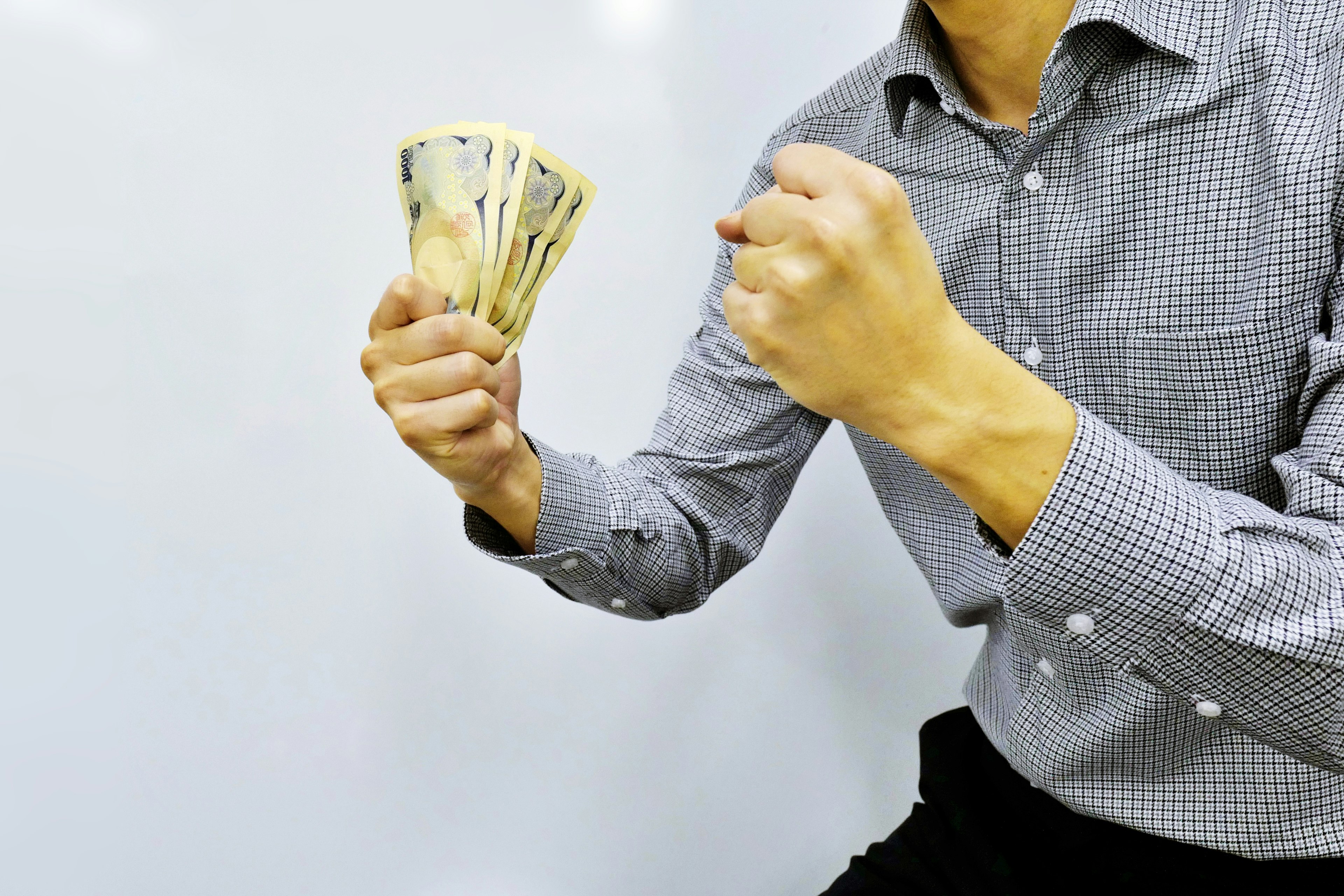 Man holding a bundle of cash with a determined expression