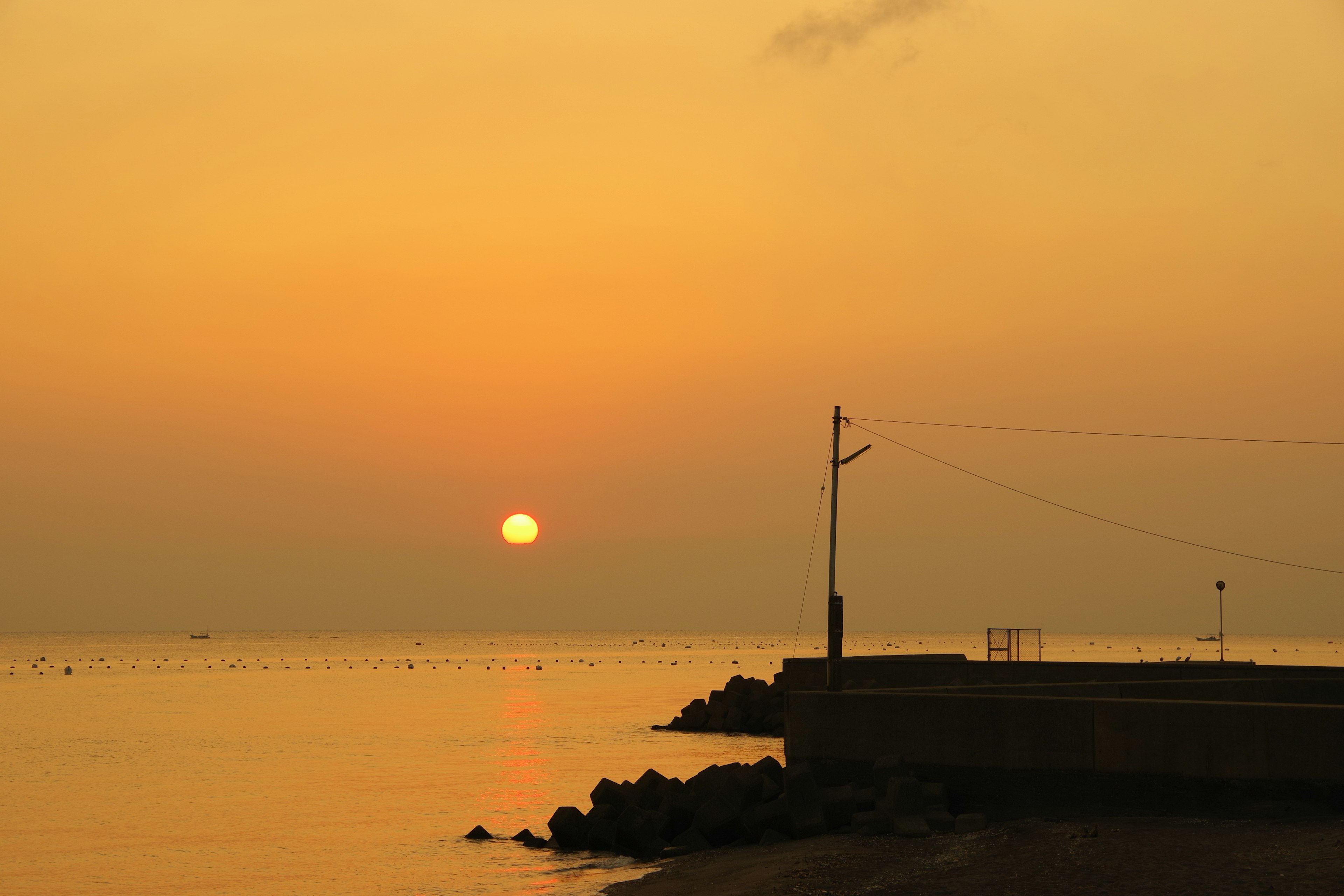 夕日が海に沈む風景と静かな水面の色合い