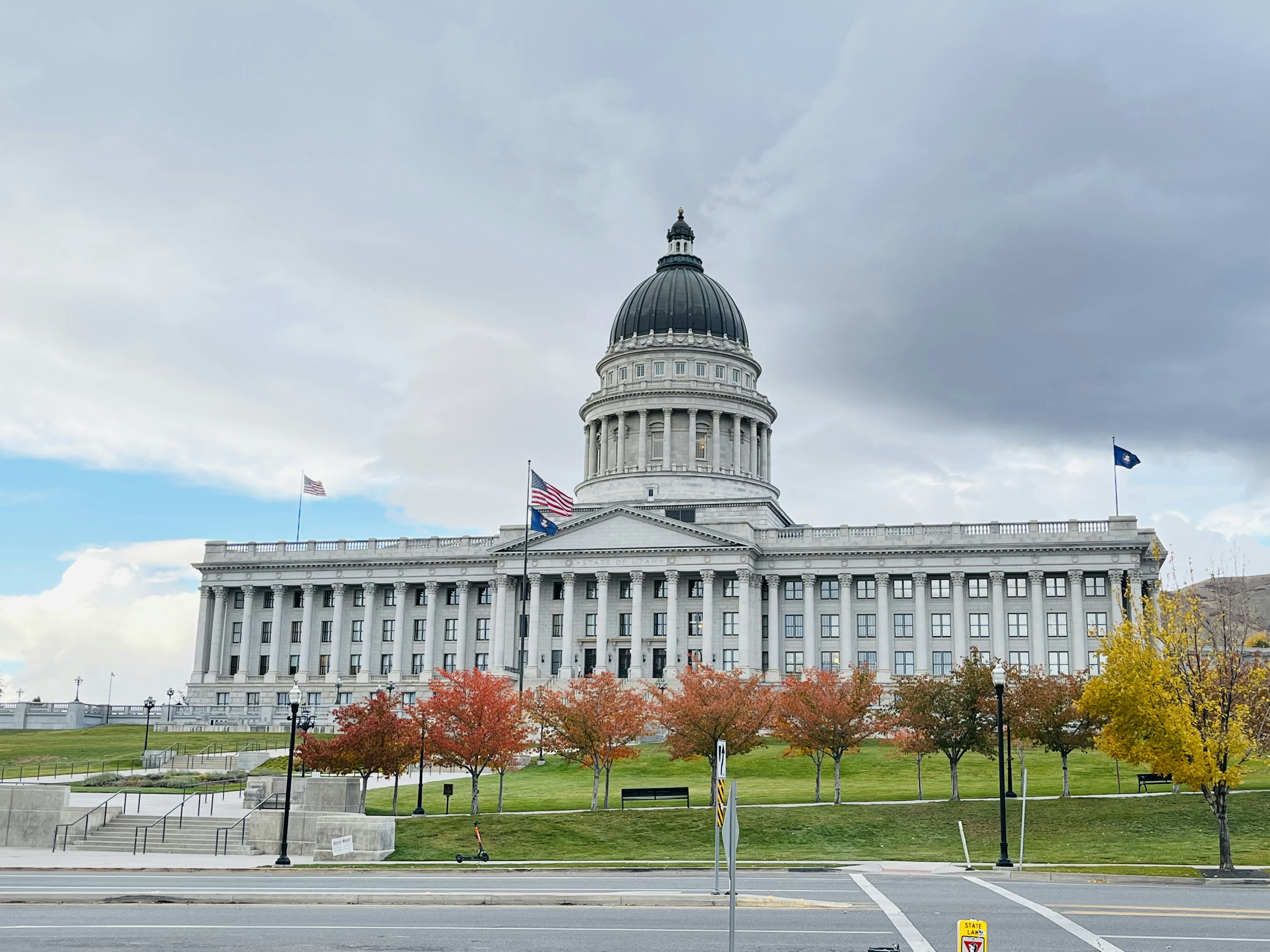 Utah State Capitol building with autumn foliage and cloudy sky