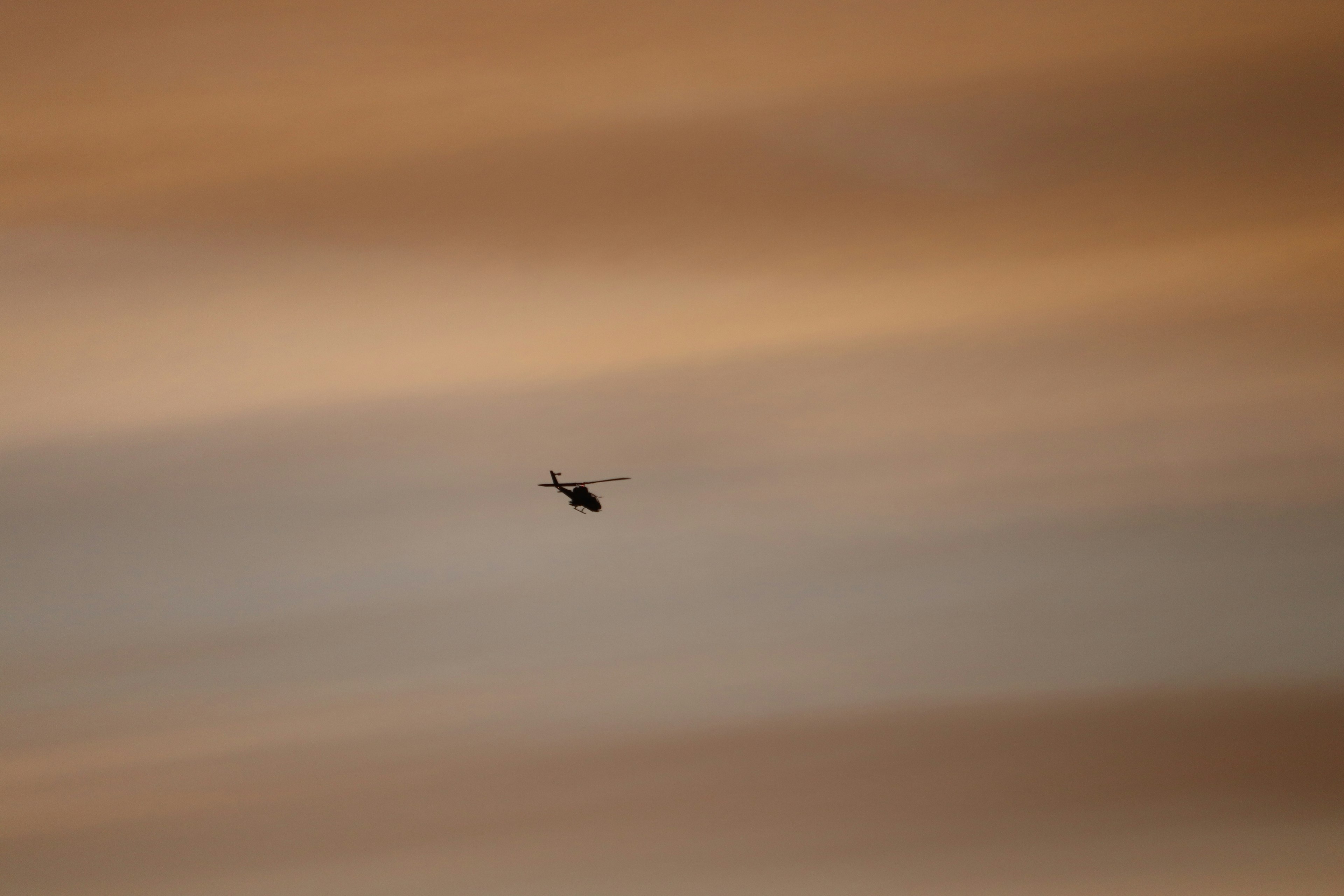 Silhouette di un elicottero contro un cielo al tramonto