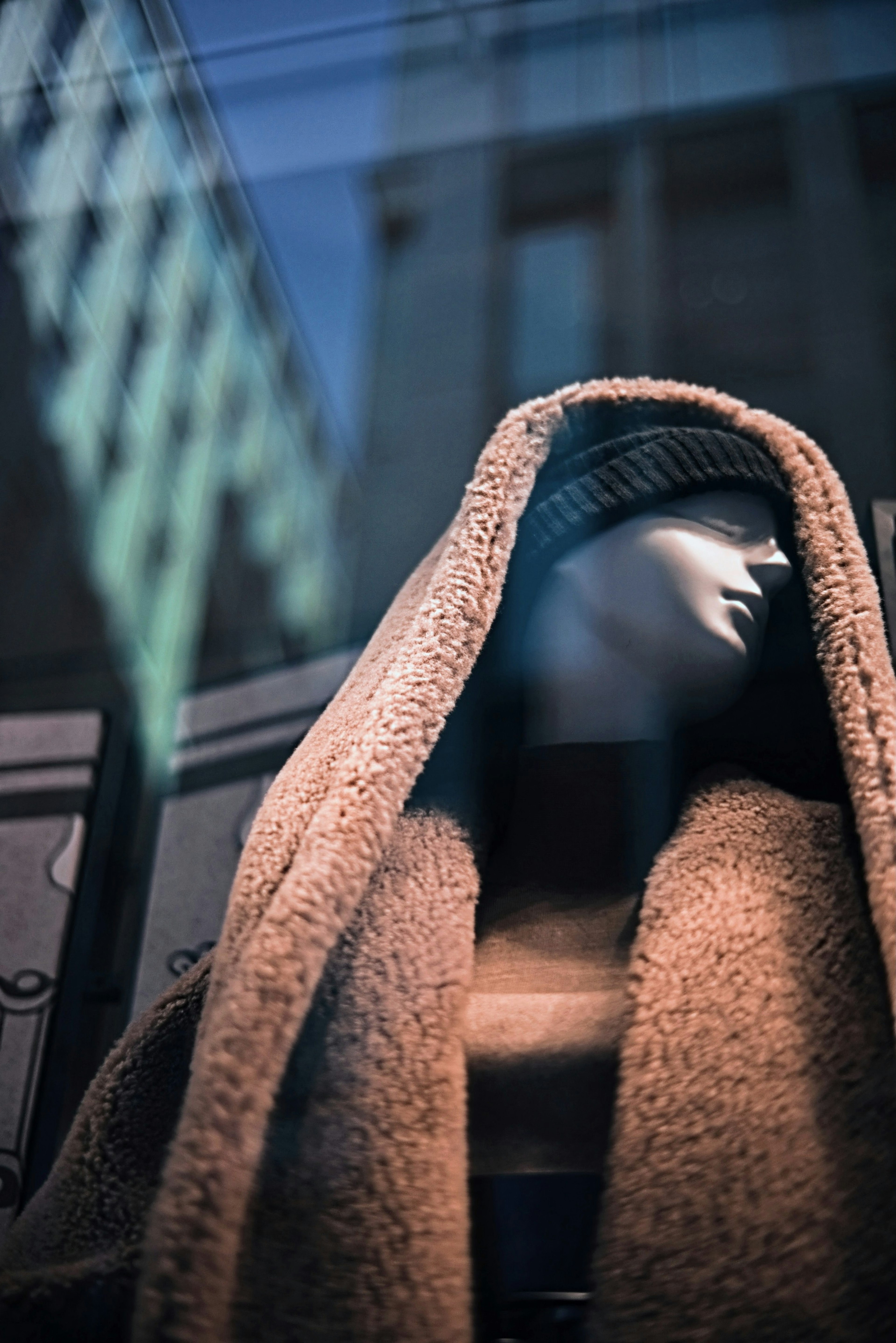 Mannequin wearing a hooded coat in a store window display