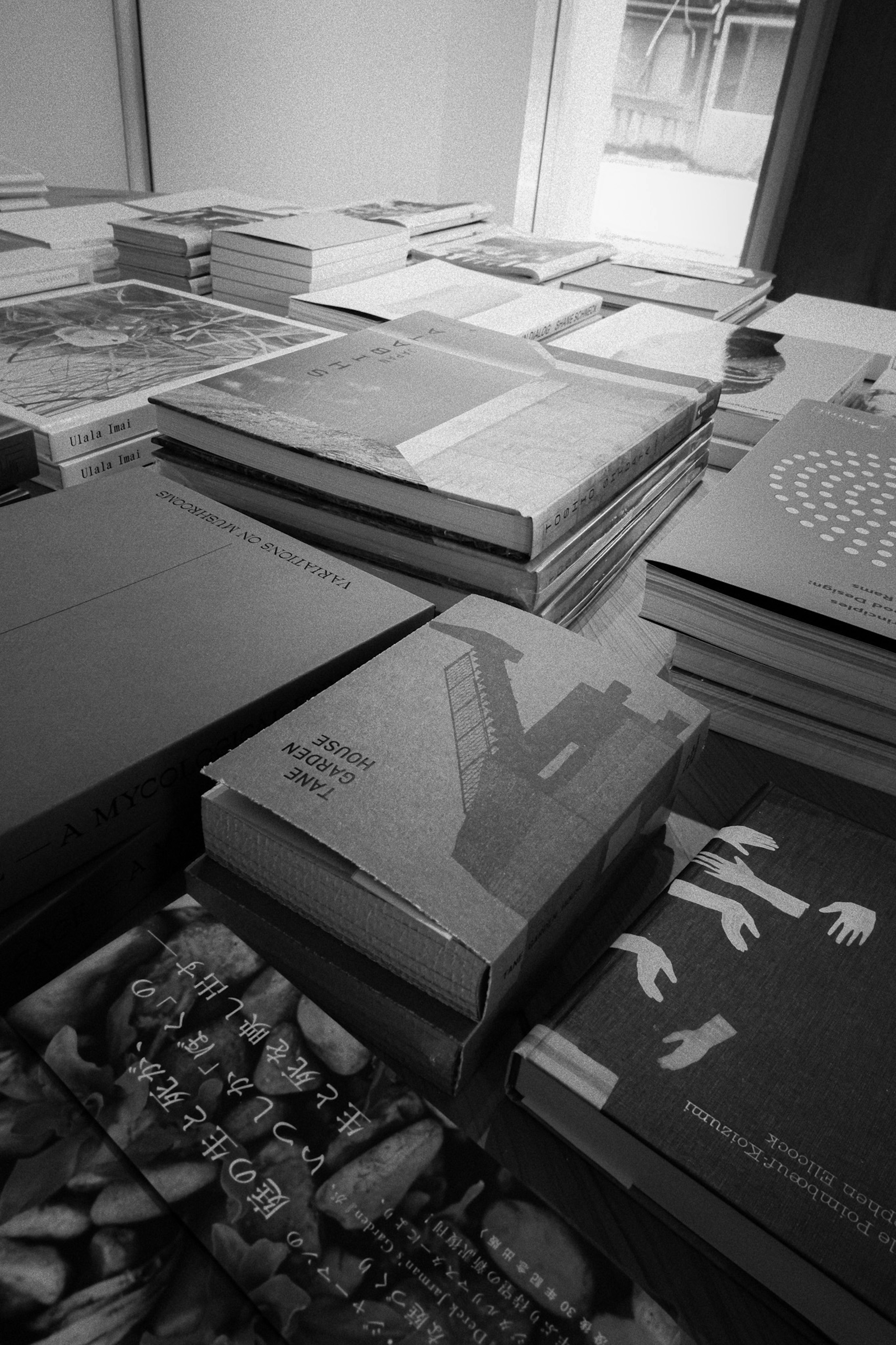 A collection of stacked books in black and white on a table