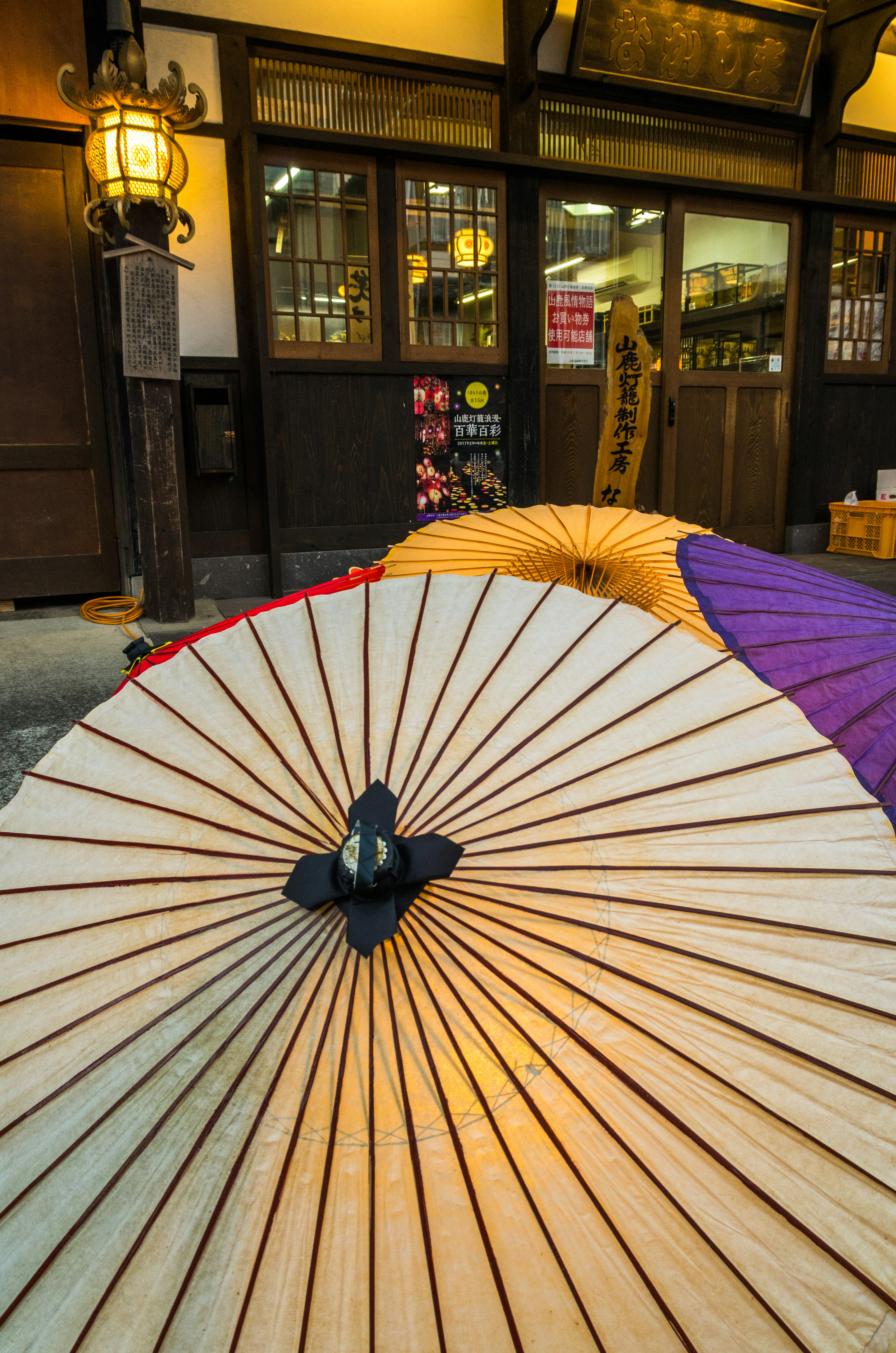 Traditional wooden umbrellas arranged with a Japanese building in the background