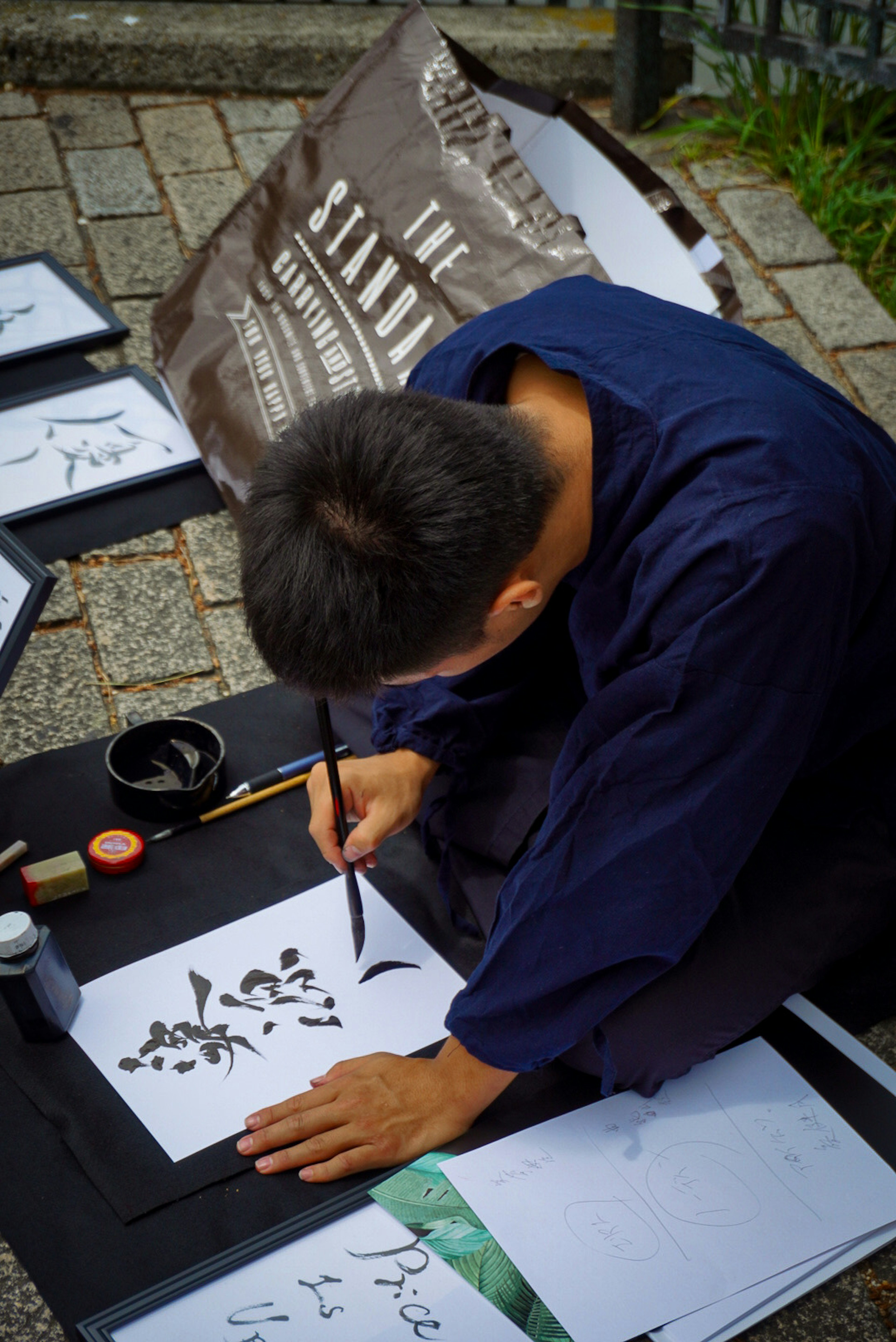 Ein Mann, der japanische Kalligraphie mit Tinte übt