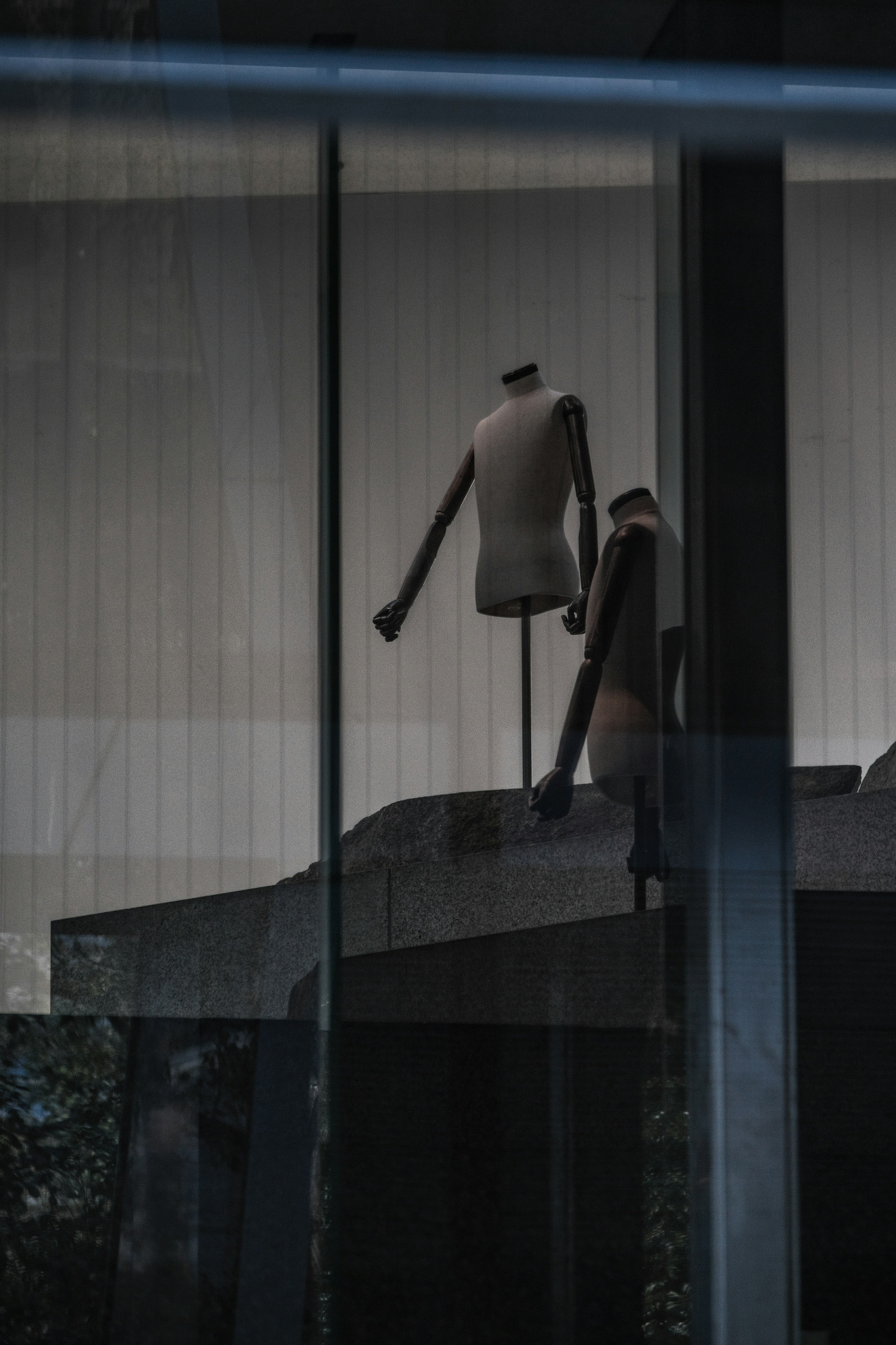 Mannequins visible through glass in a fashion display window