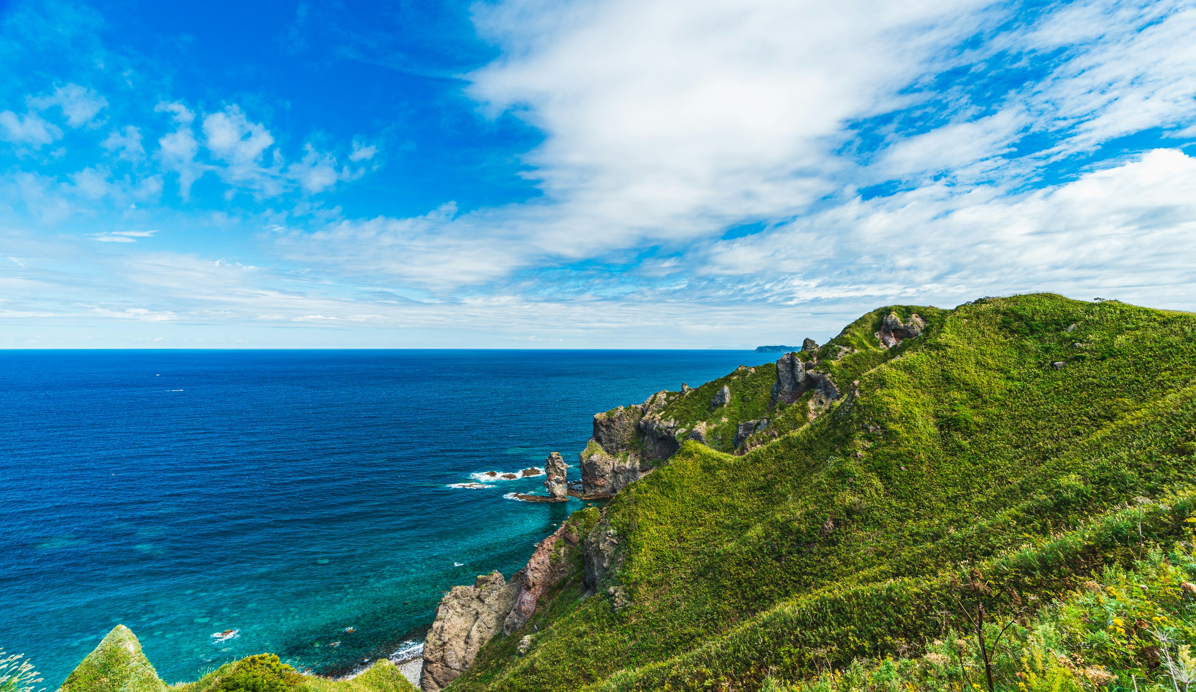 Vista panoramica dell'oceano blu e delle colline verdi