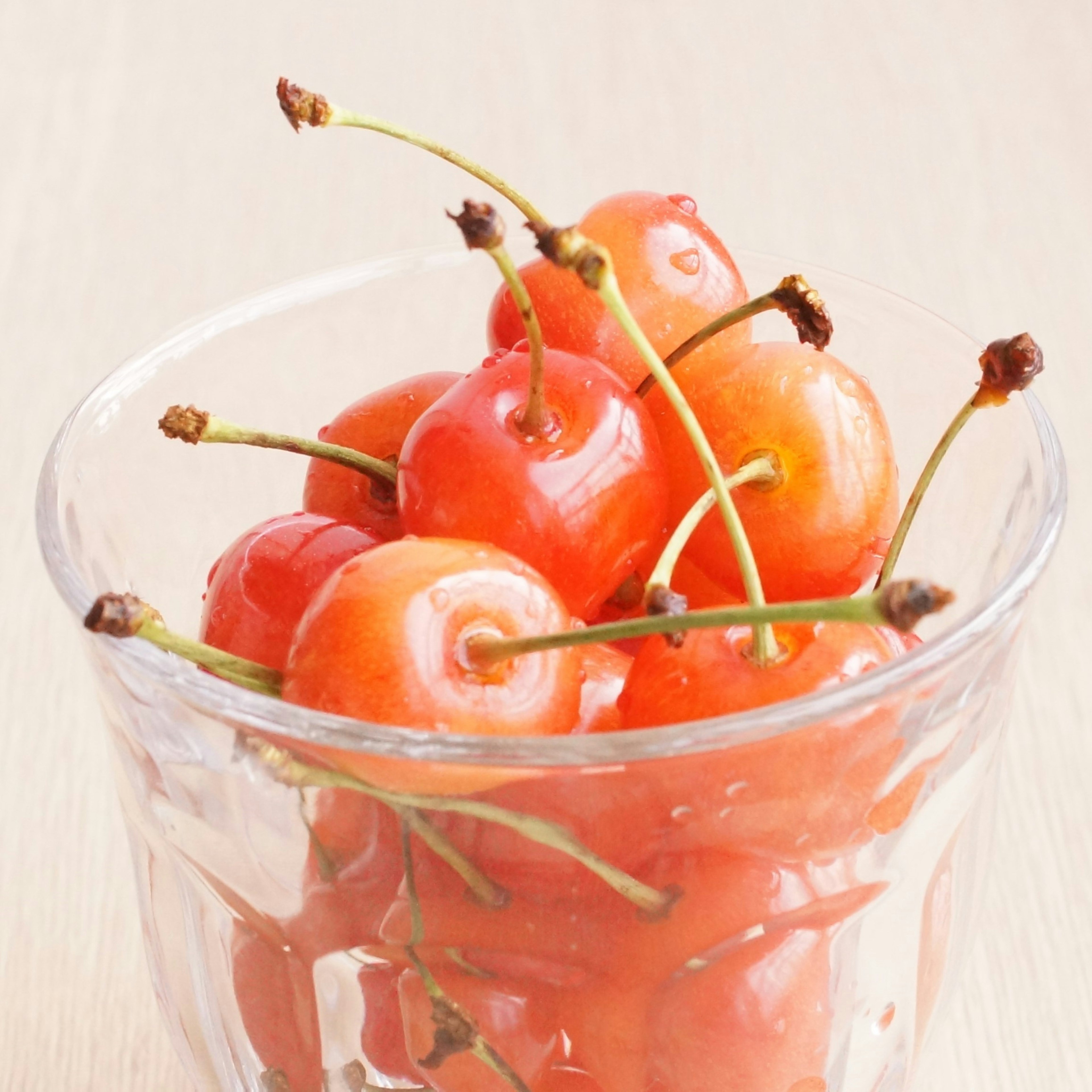 Cerezas rojas en un tazón de vidrio transparente