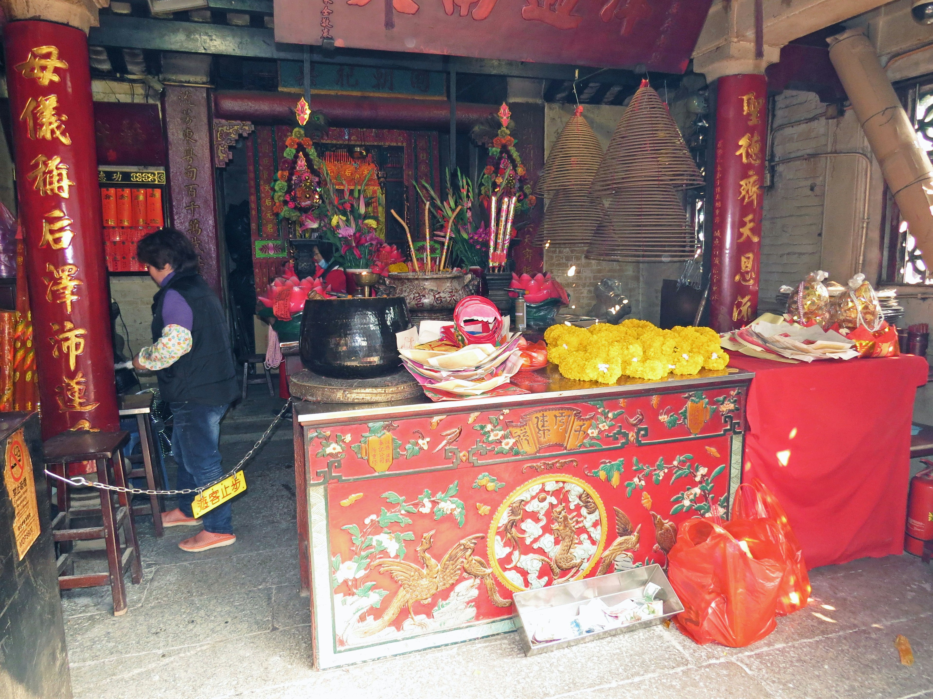 Intérieur d'un temple traditionnel avec un autel décoré des piliers rouges et des offrandes