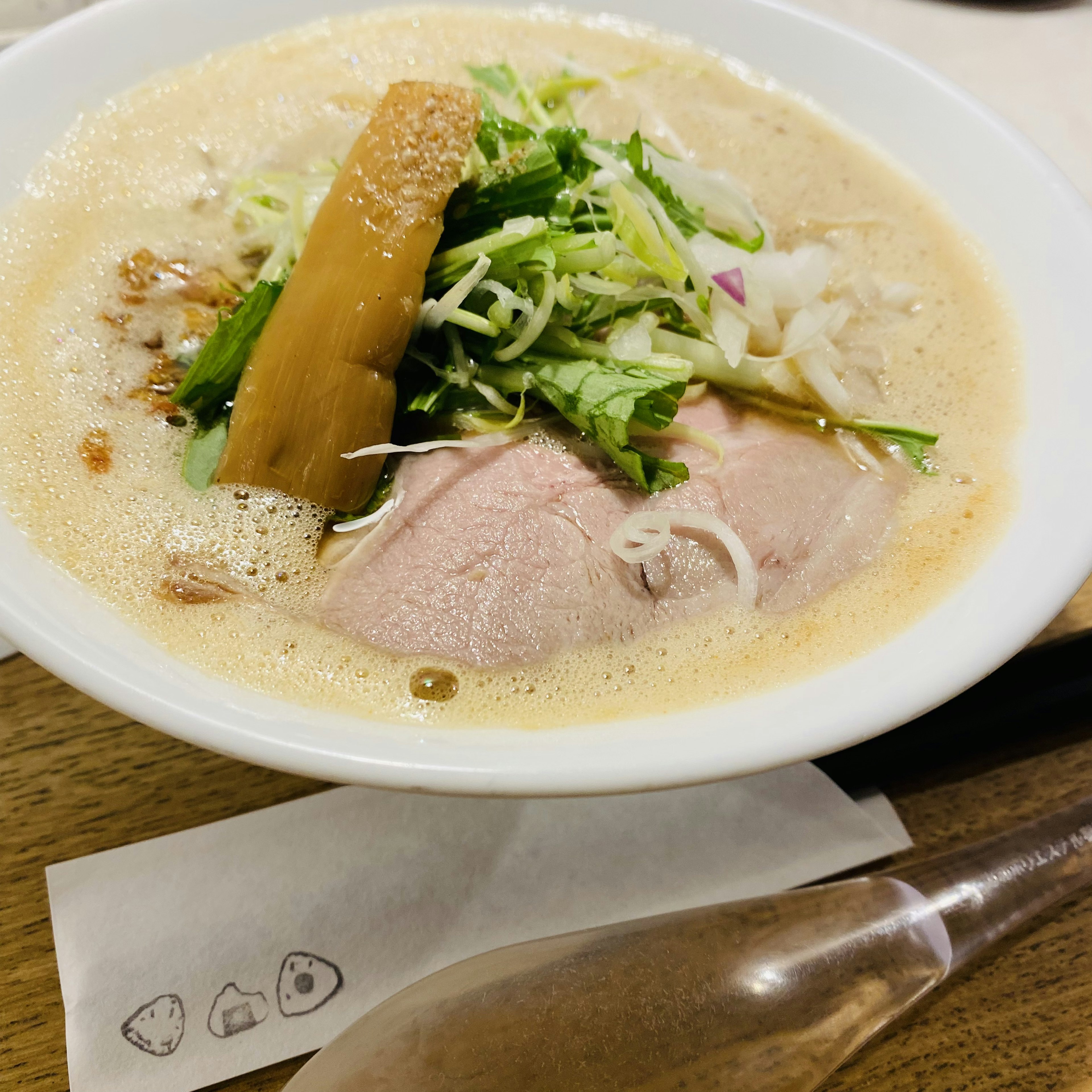 Bowl ramen dengan irisan daging babi dan sayuran campuran di atasnya