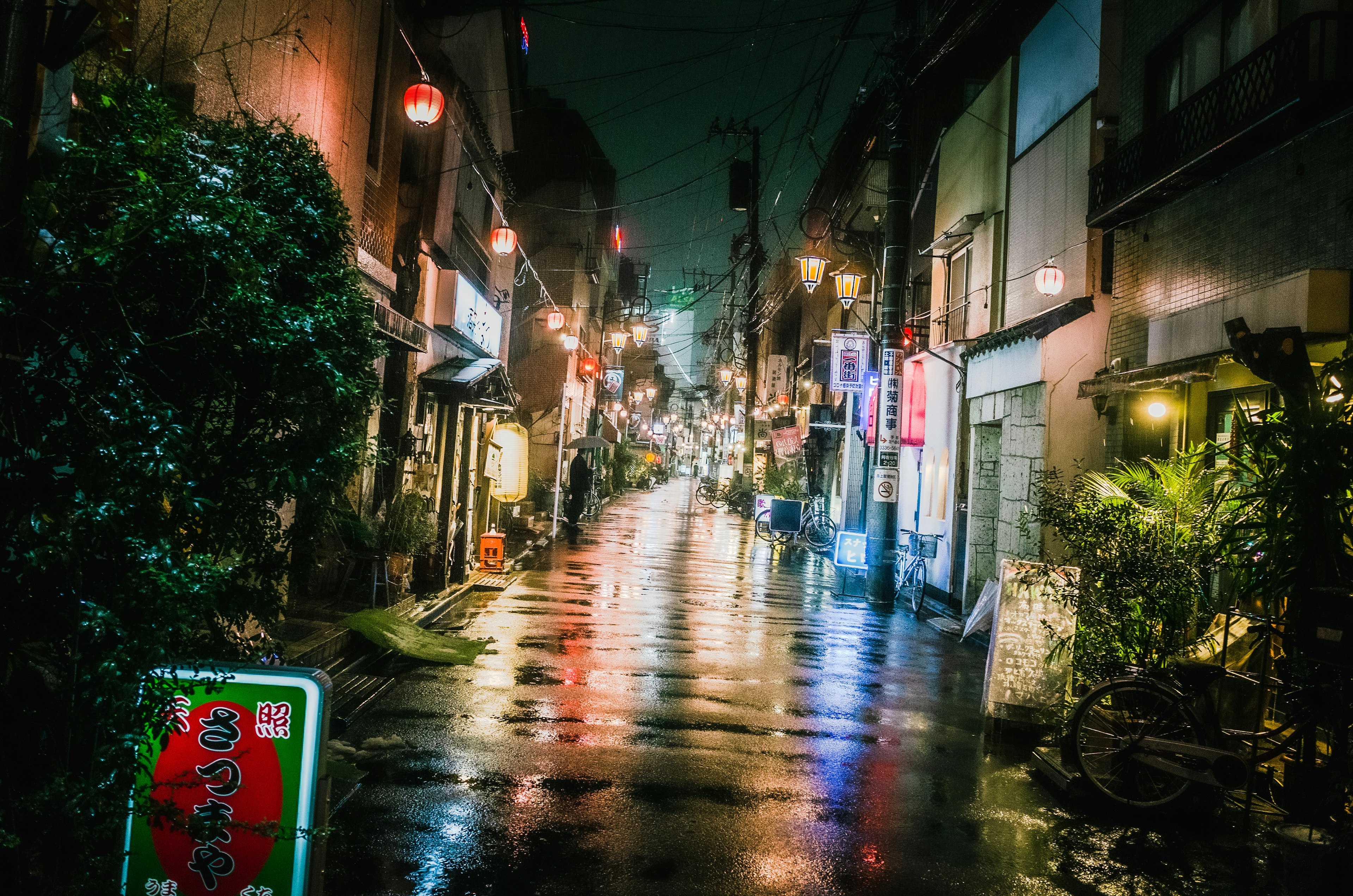 Rain-soaked street scene at night with neon lights