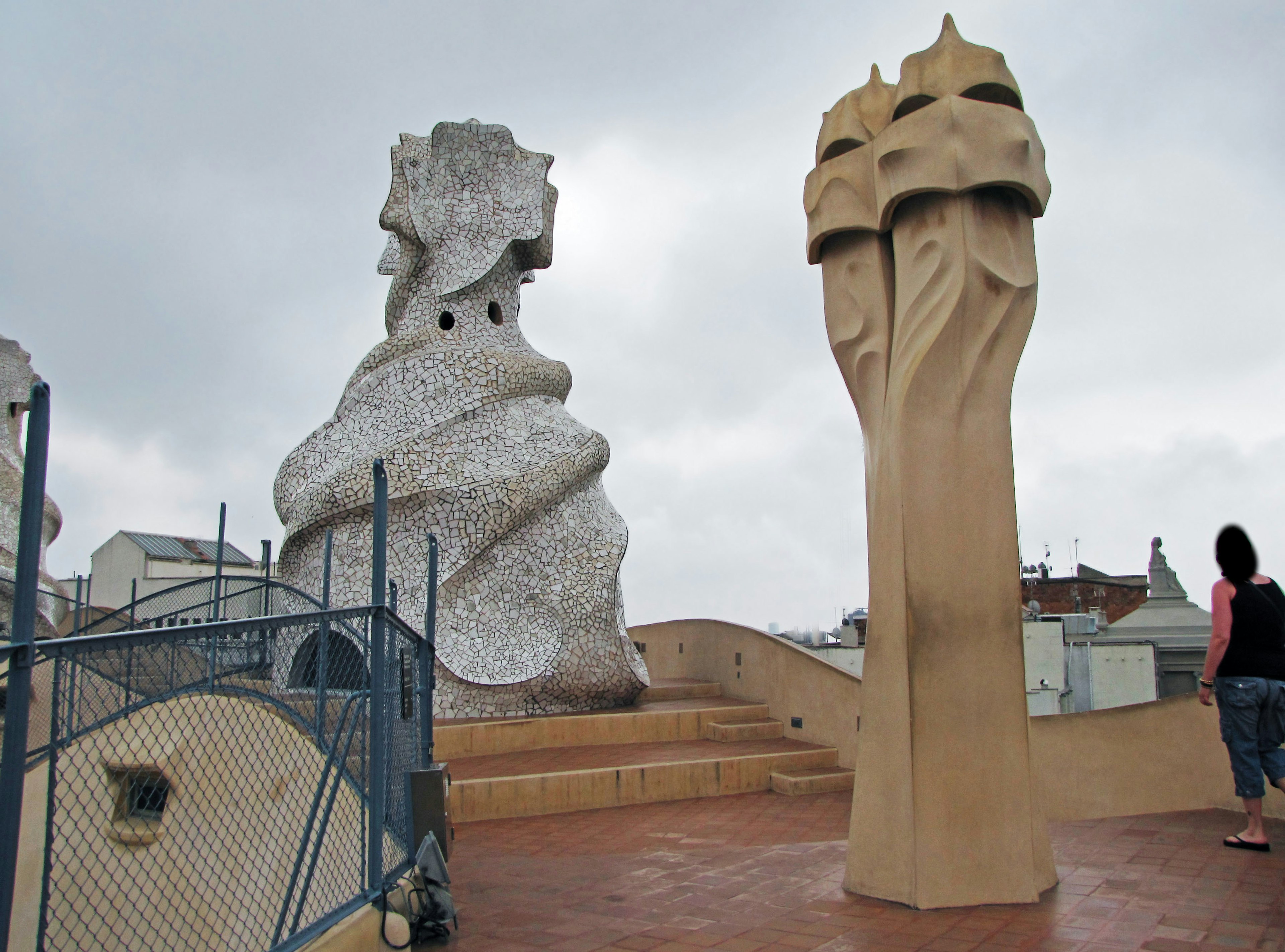 Tượng độc đáo trên mái Casa Mila với một người gần đó