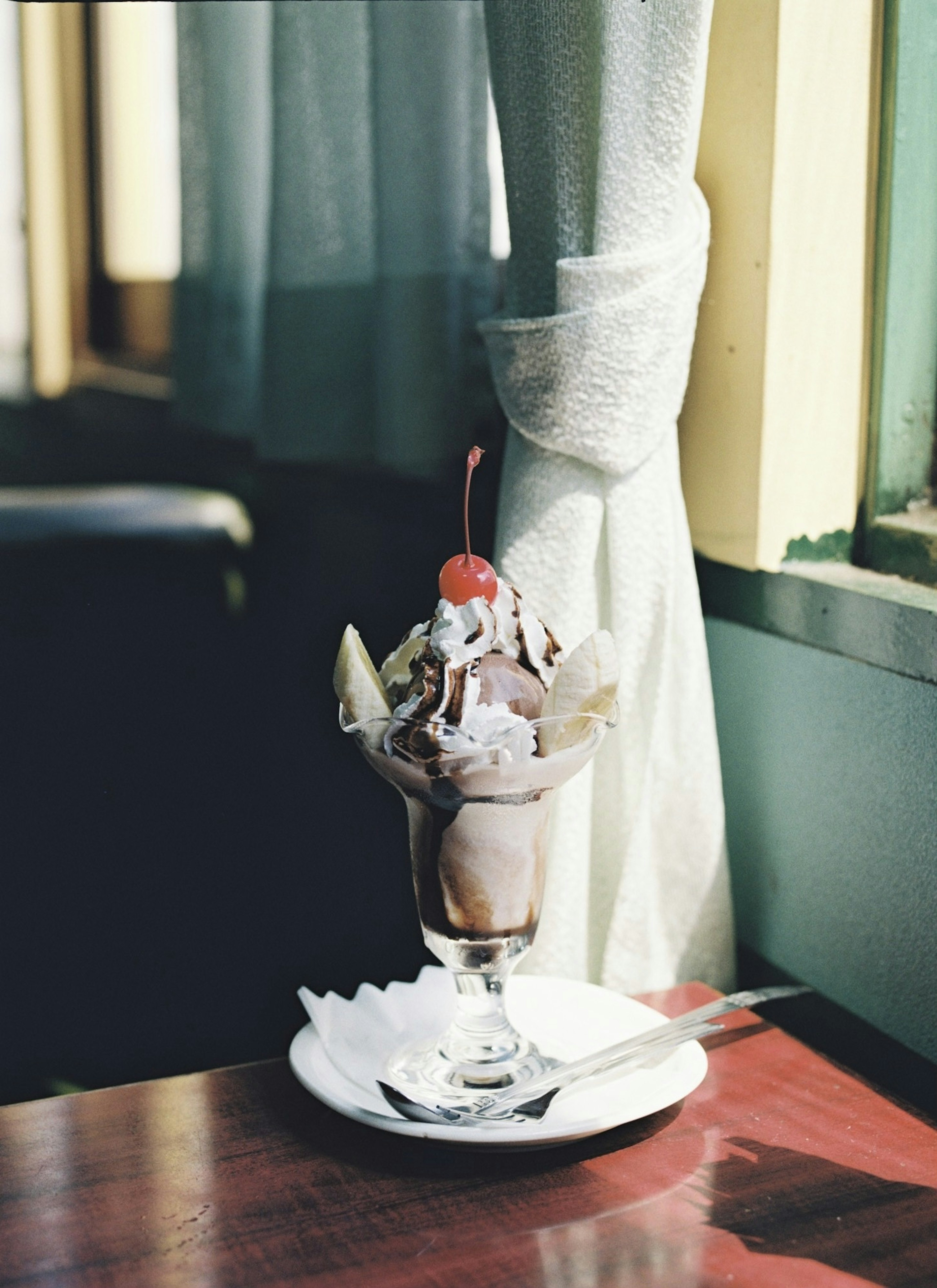 Ice cream sundae served in a glass dish on a wooden table