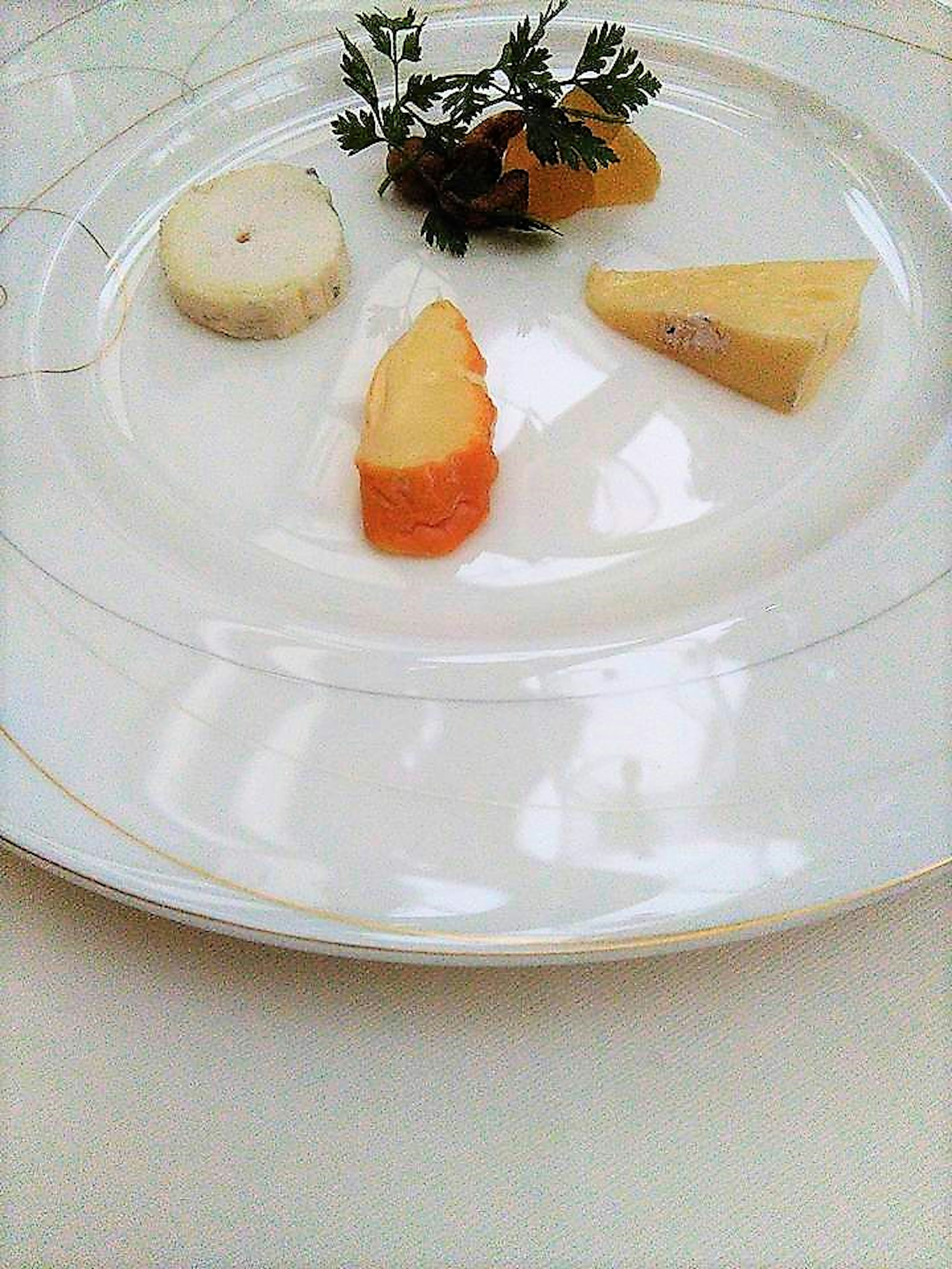 A selection of cheeses and herbs arranged on a white plate